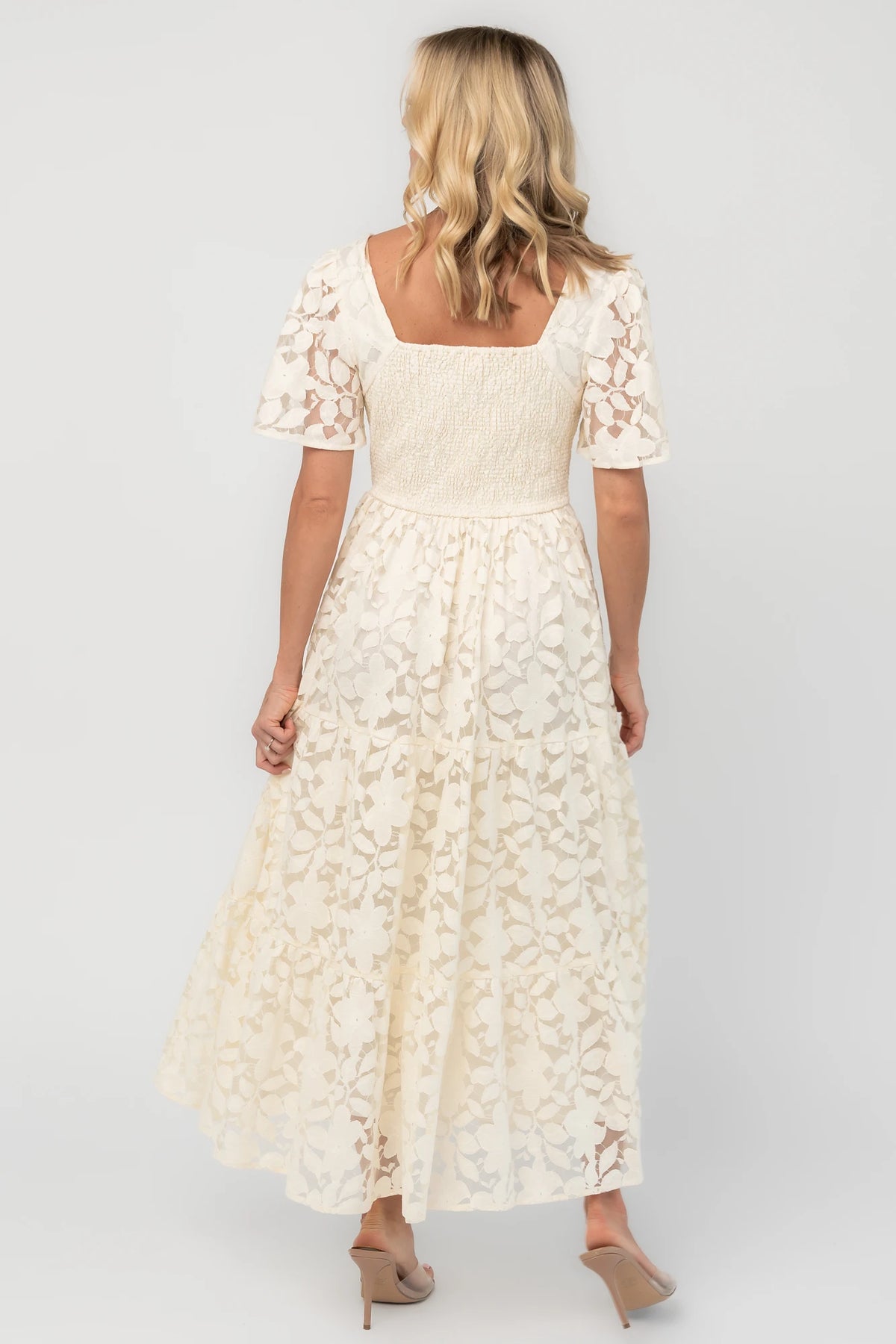 Floral lace midi dress with a deep V-neckline, short flutter sleeves, smocked back bodice, defined waistband, and tiered skirt.