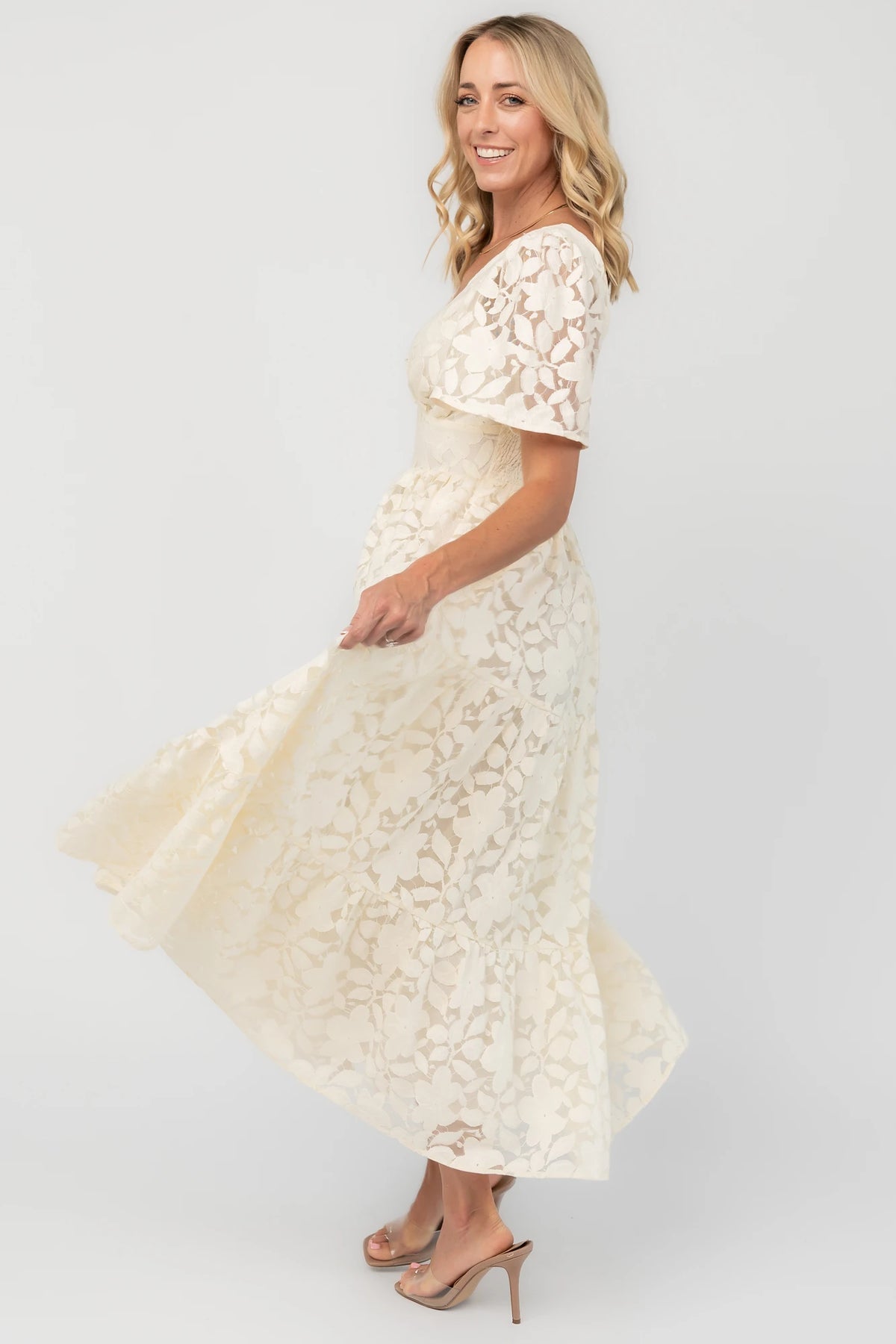 Floral lace midi dress with a deep V-neckline, short flutter sleeves, smocked back bodice, defined waistband, and tiered skirt.