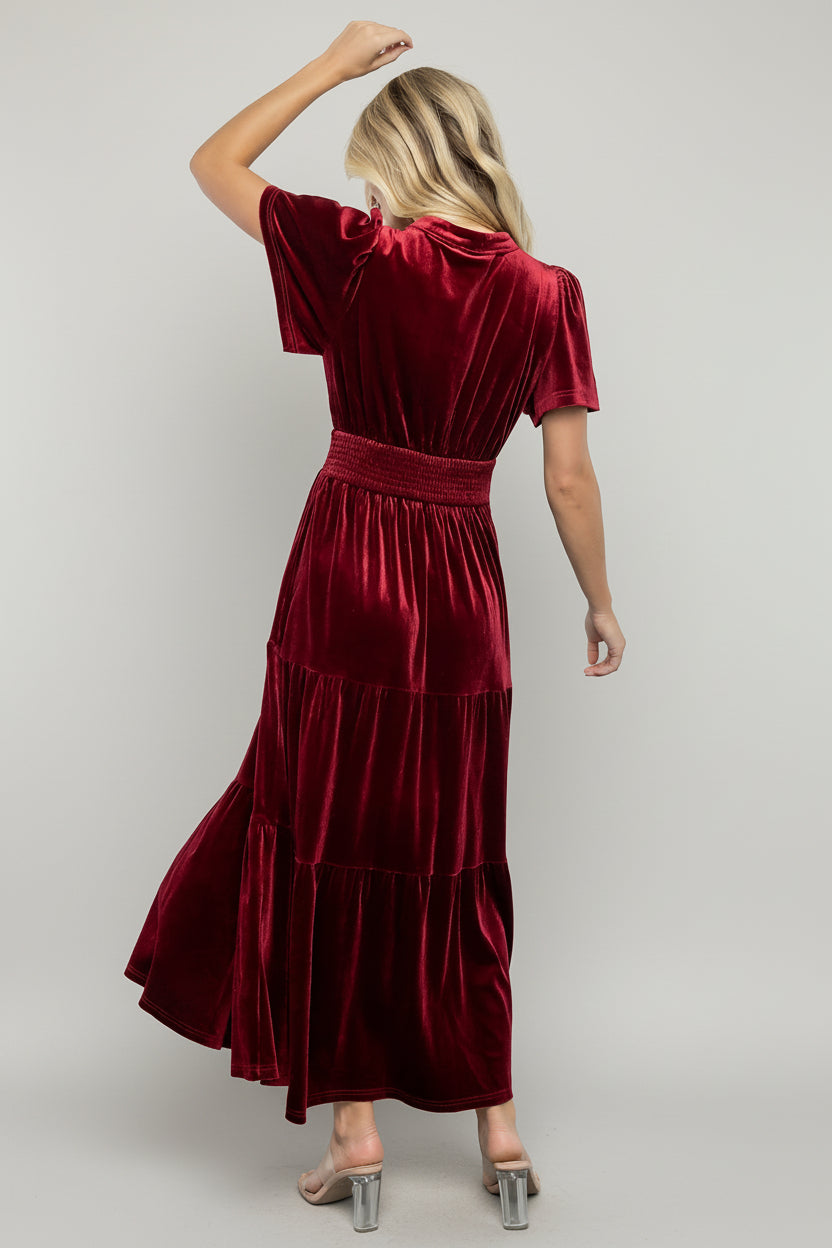 Side view of Maida embroidered velvet maxi dress showing smocked waistband, flowing tiers and the dress’s full lining for smooth wear.