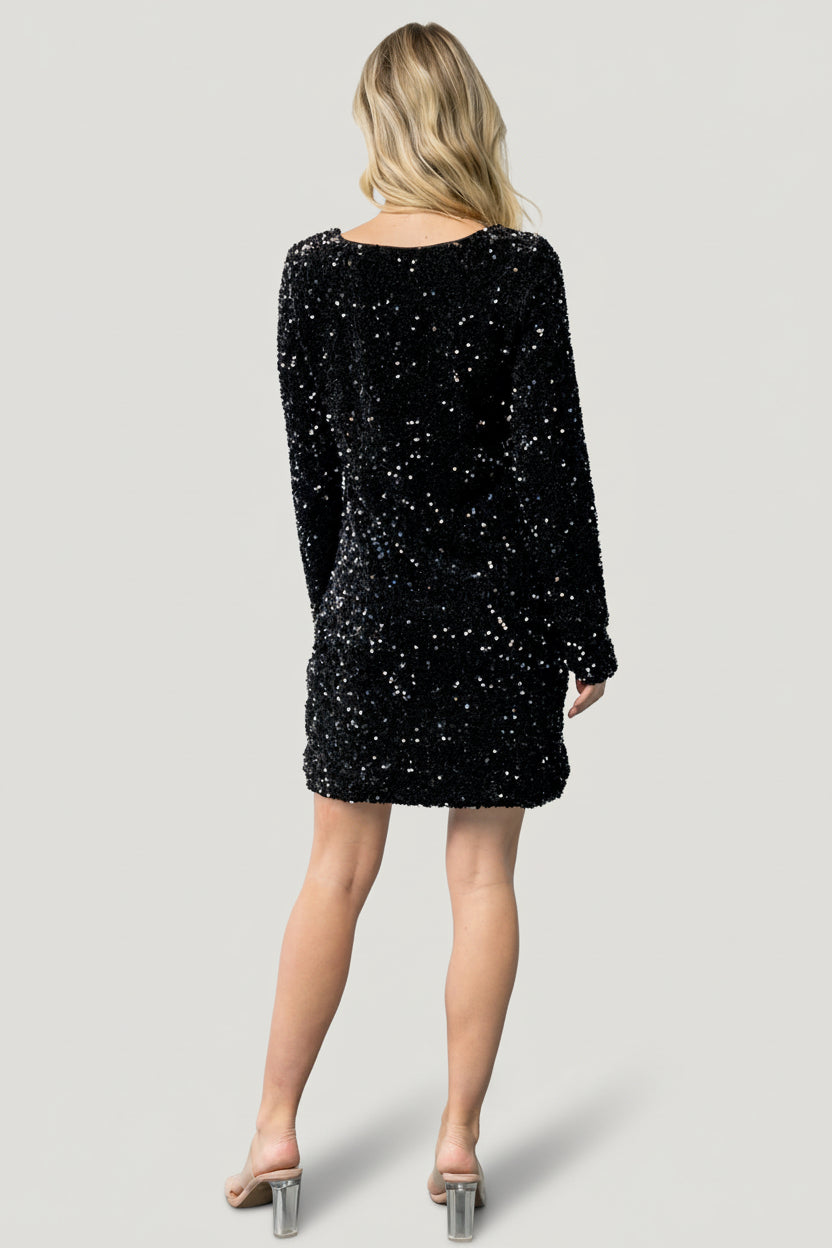Close-up of monochrome sequin texture on black velvet showing sequin placement, fabric sheen, and lining edge.
