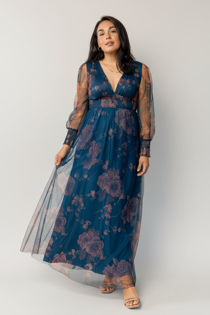Close-up of copper metallic floral print on deep blue tulle, highlighting metallic threads, floral motifs, and fabric texture under soft studio lighting.