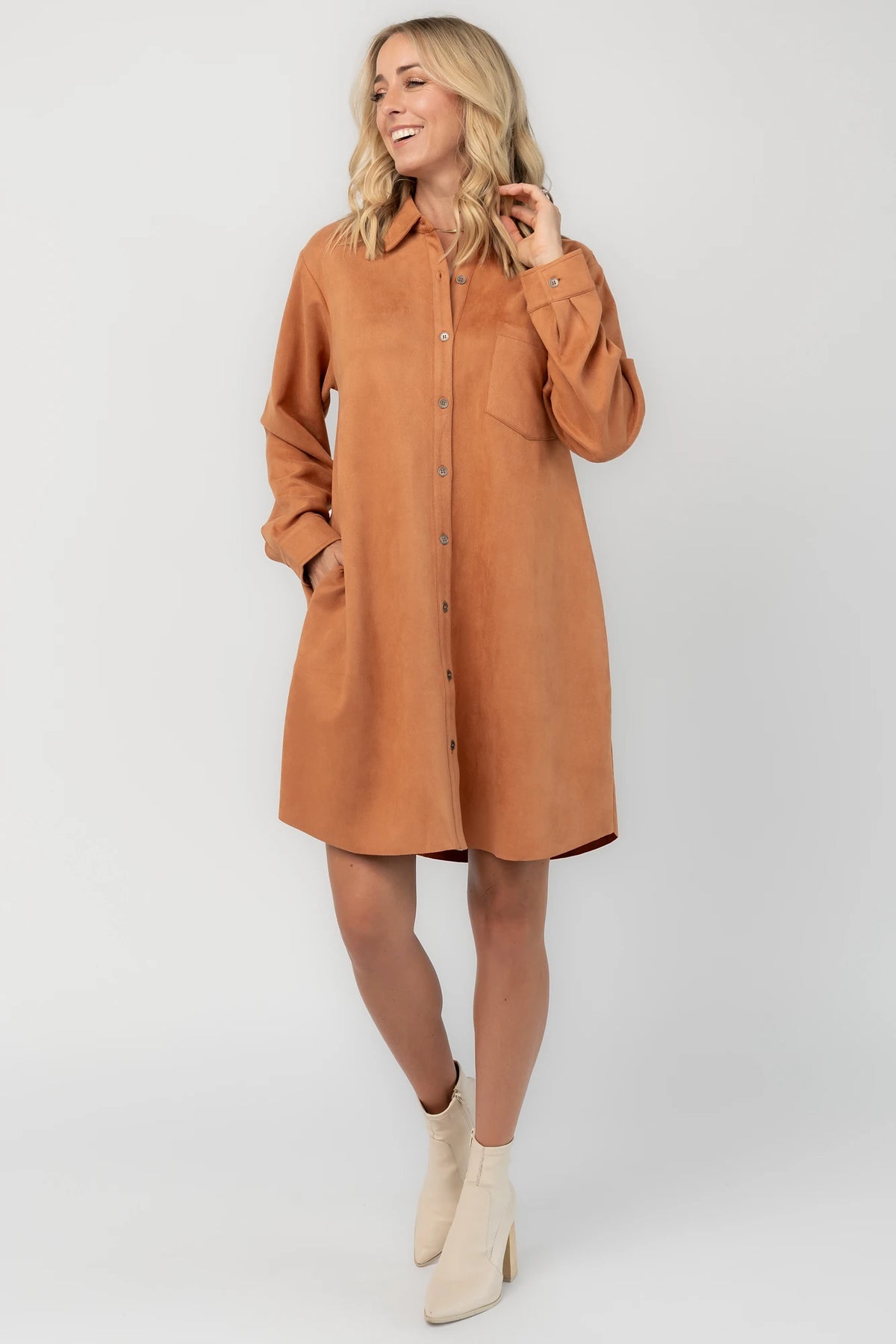 Camel faux suede shirt dress with a collared neckline, button-front closure, front patch pocket, long sleeves, and a relaxed oversized silhouette.