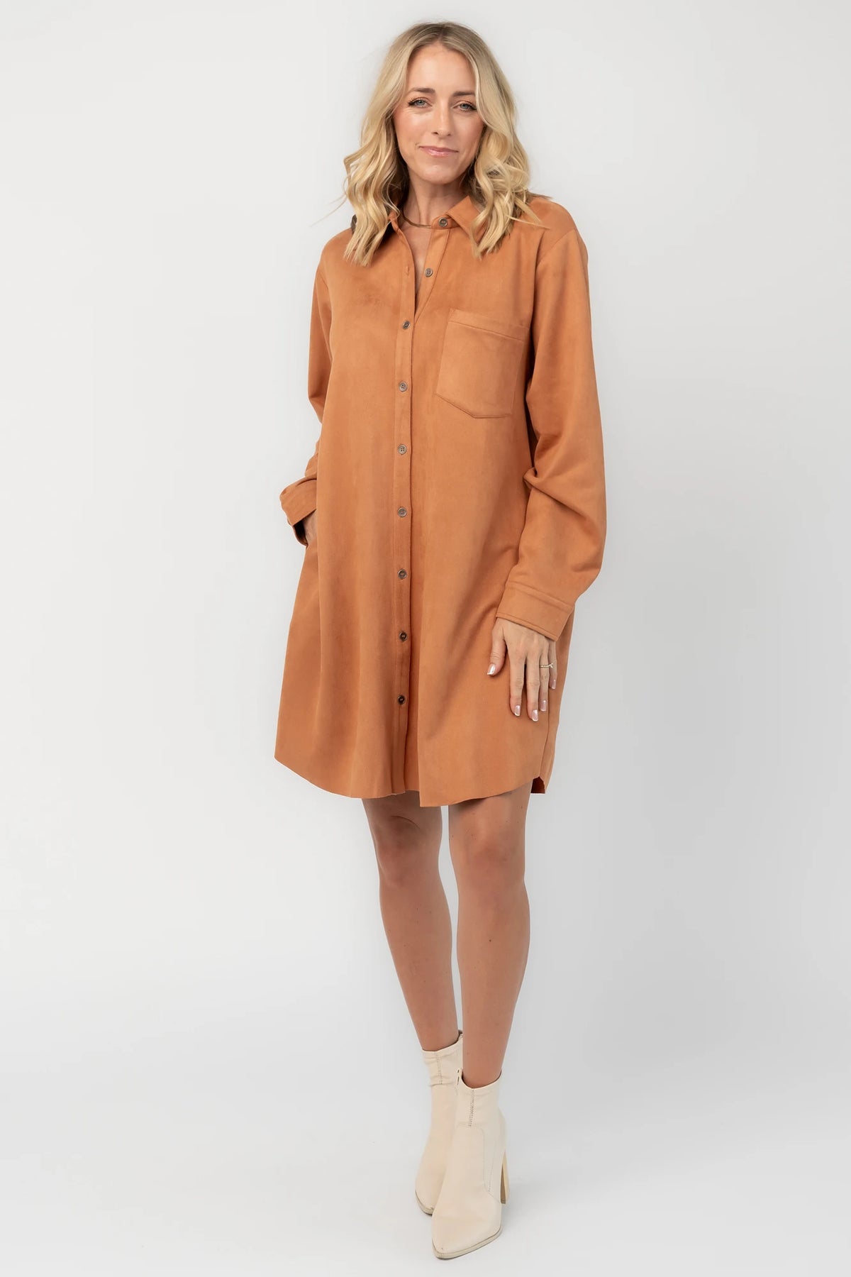 Camel faux suede shirt dress with a collared neckline, button-front closure, front patch pocket, long sleeves, and a relaxed oversized silhouette.