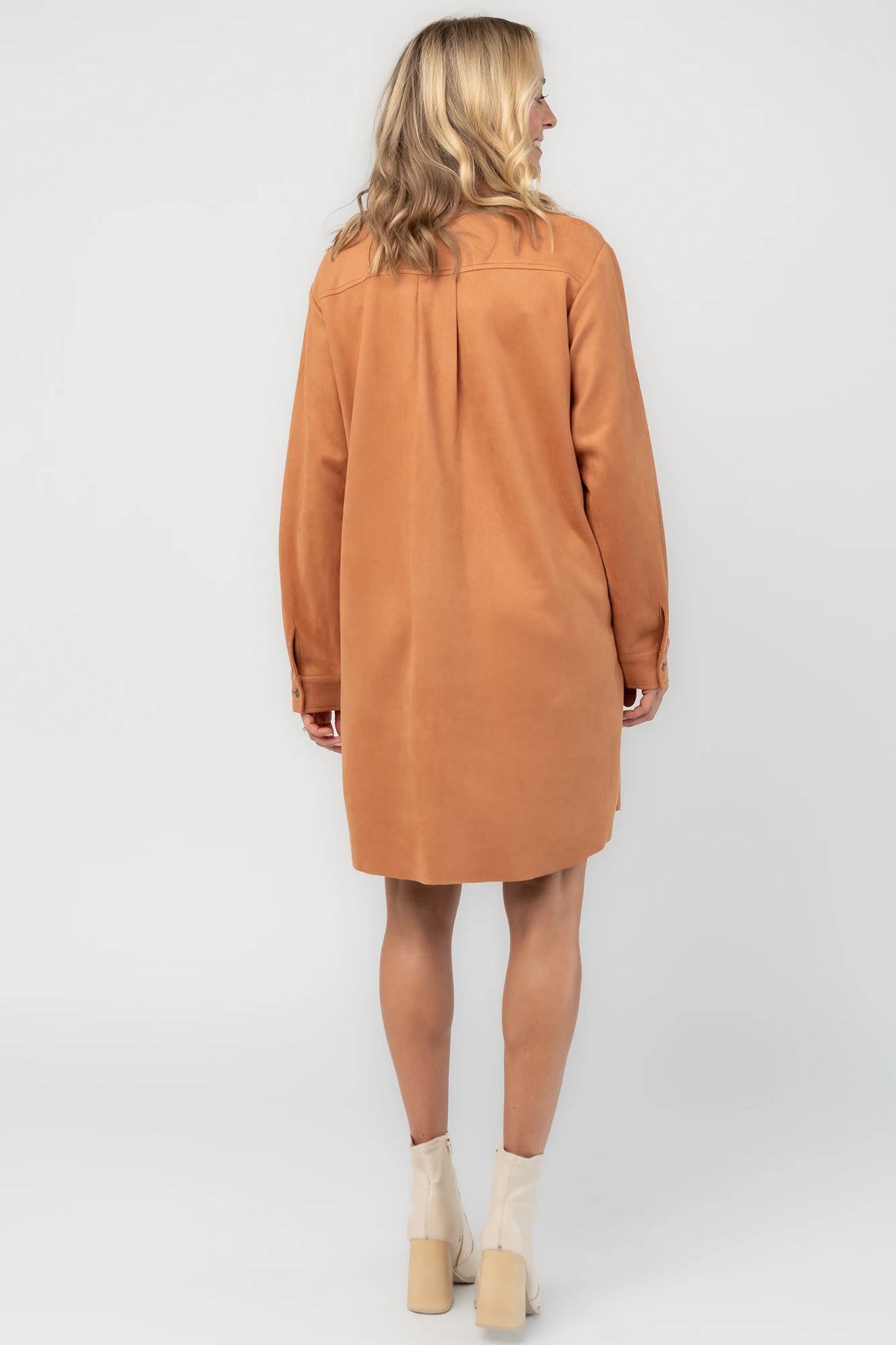 Camel faux suede shirt dress with a collared neckline, button-front closure, front patch pocket, long sleeves, and a relaxed oversized silhouette.
