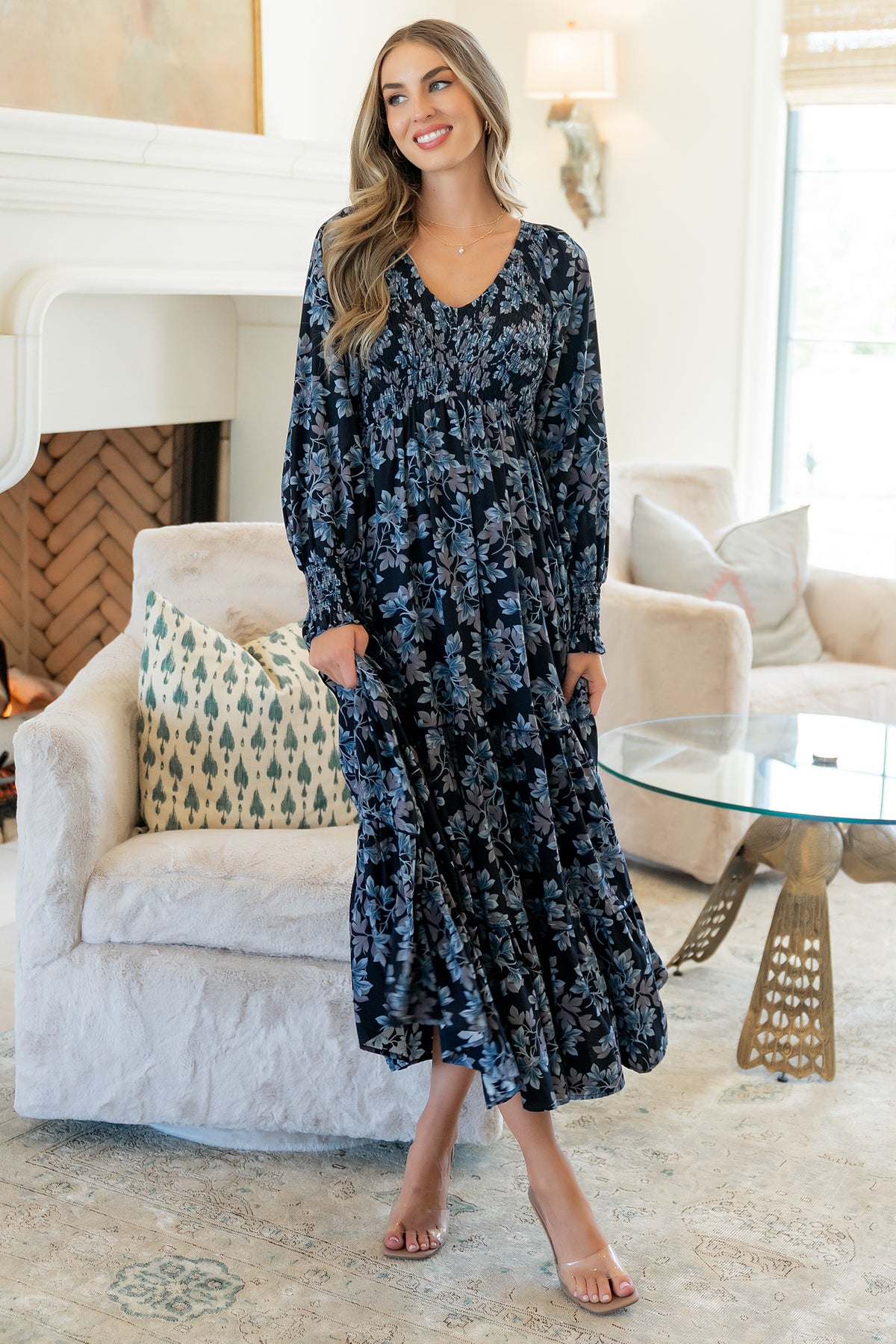 Front view of model wearing Rayna Smocked Maxi Dress in midnight blue floral, V-neck and tiered skirt visible, full-length pose.