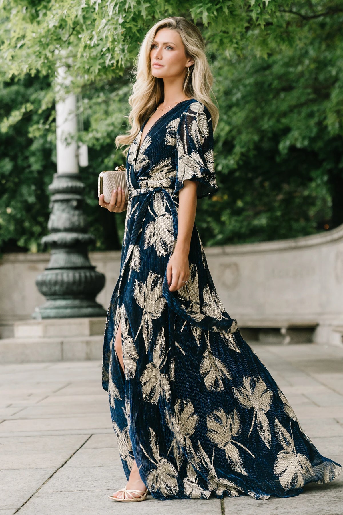 Rachel Maxi Dress in Navy + Gold with shimmer finish, surplice neckline, self-tie sash, long sleeves, and leg slit.