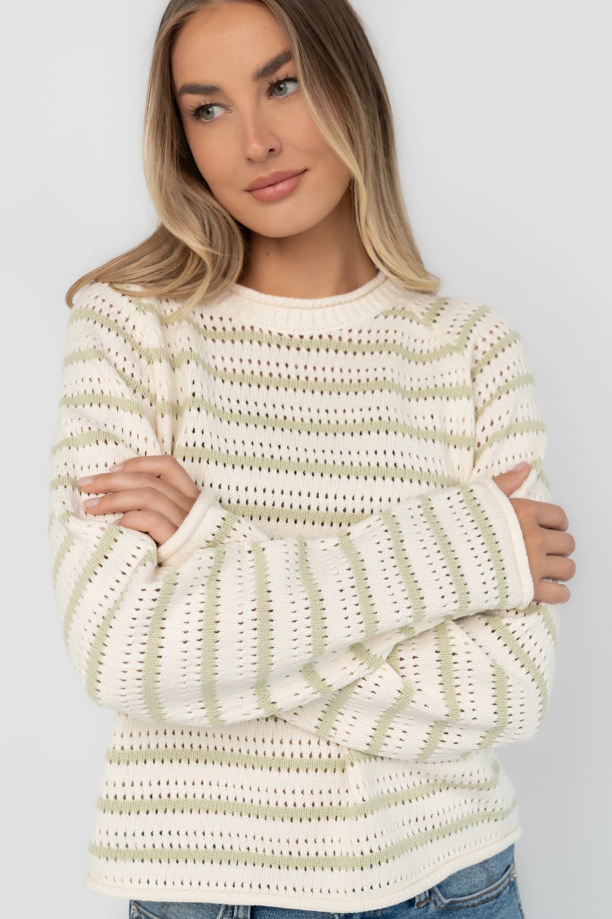 Cream and sage striped open-knit sweater with a round neckline, long sleeves, rolled trim, and a relaxed fit.