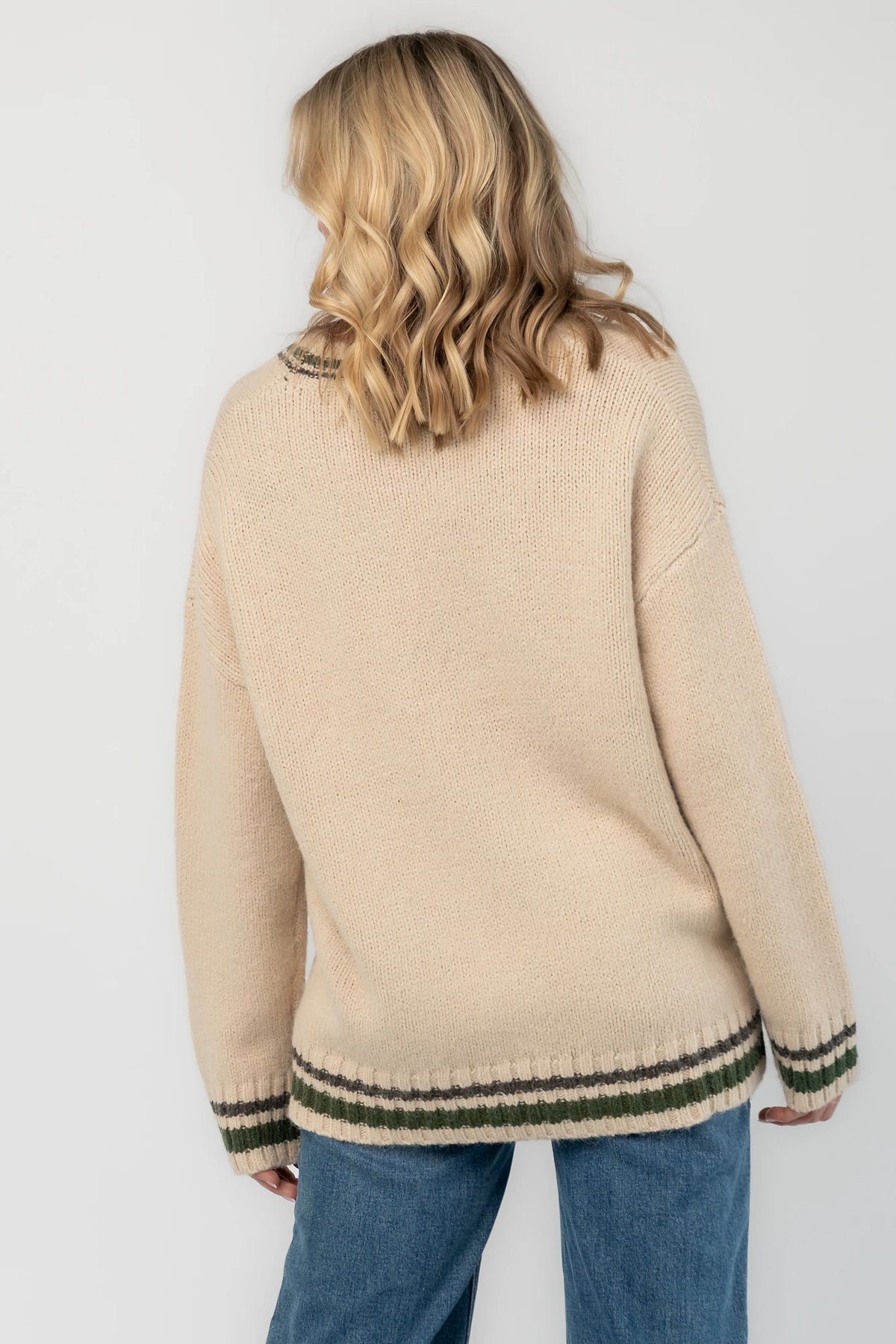 Oatmeal knit cardigan with a V-neckline, button-front closure, olive and charcoal striped trim, front patch pockets, and a relaxed fit.