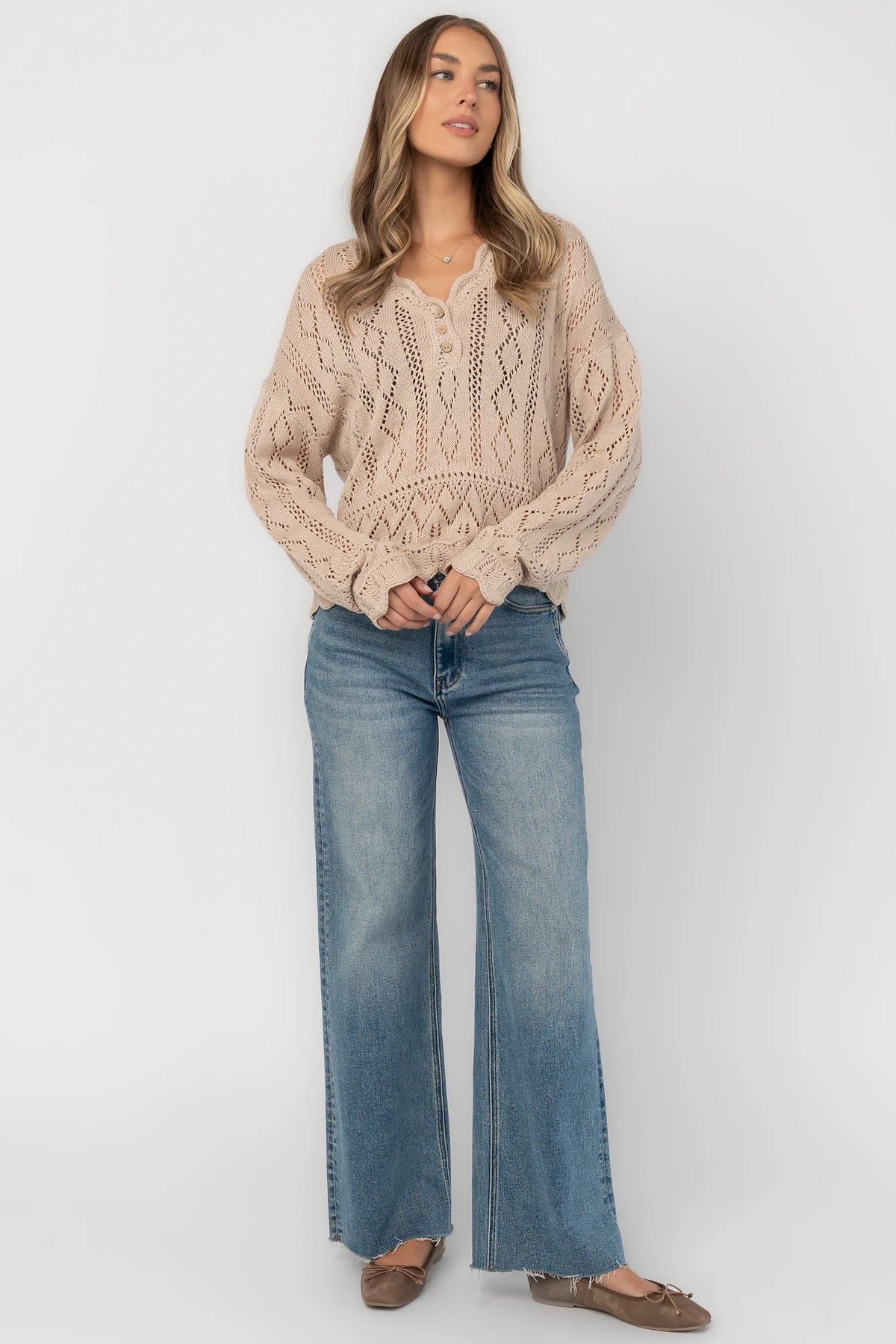 Oatmeal pointelle knit sweater with a scalloped henley neckline, functional button front, dropped shoulders, long sleeves, and a scalloped hem.