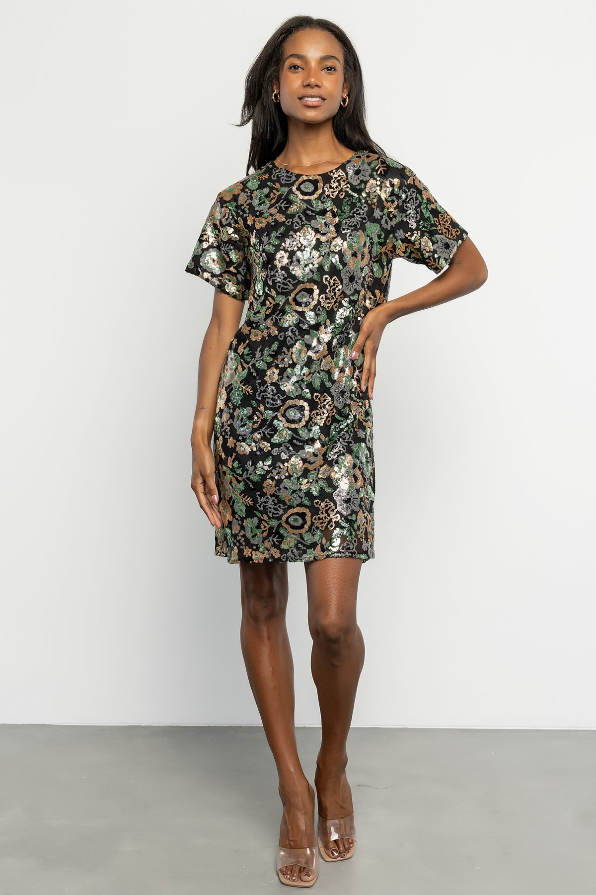 Three-quarter view of Squires sequin short dress showing fitted bodice, short skirt length, and multicolored floral sequin pattern on black mesh.