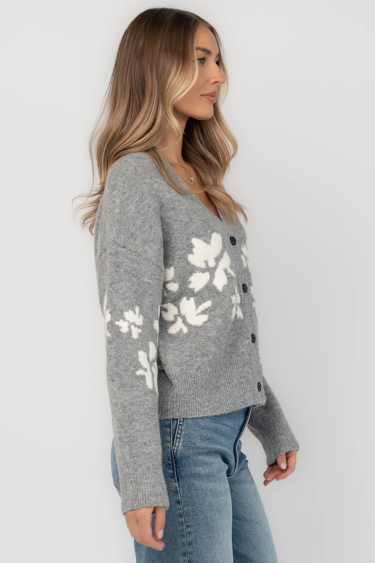 Gray floral knit cardigan with a V-neckline, button-front closure, long sleeves, ribbed trim, and a relaxed silhouette.