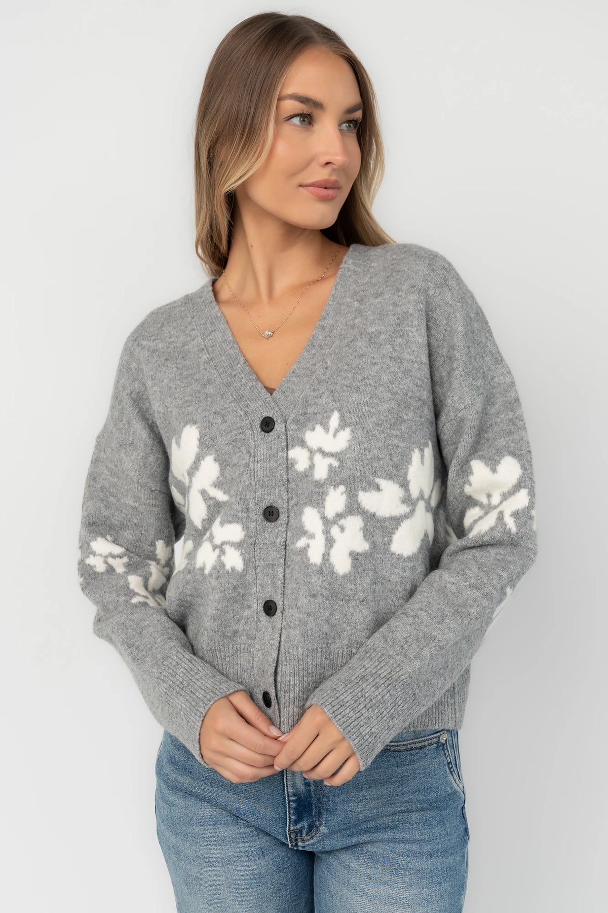 Gray floral knit cardigan with a V-neckline, button-front closure, long sleeves, ribbed trim, and a relaxed silhouette.