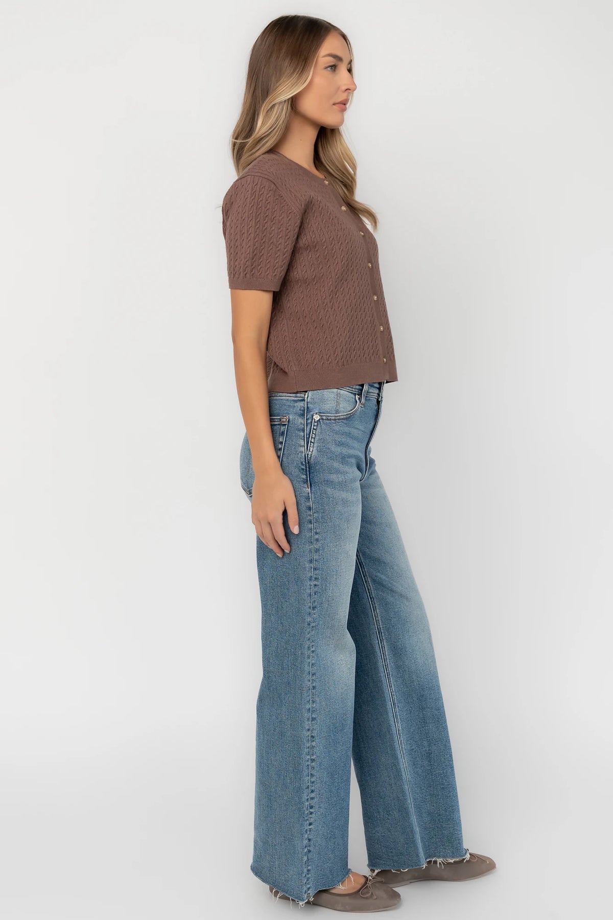 Brown cable knit cardigan with a round neckline, short sleeves, button-front closure, ribbed trim, and a relaxed fit.