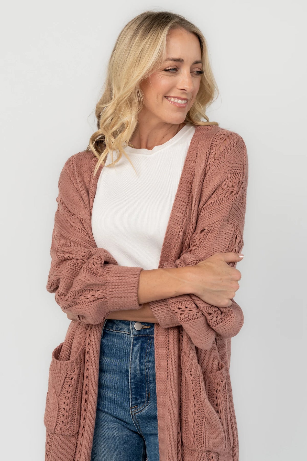 Dusty rosewood cable knit cardigan with an open front, long balloon sleeves, front patch pockets, and a relaxed longline silhouette.