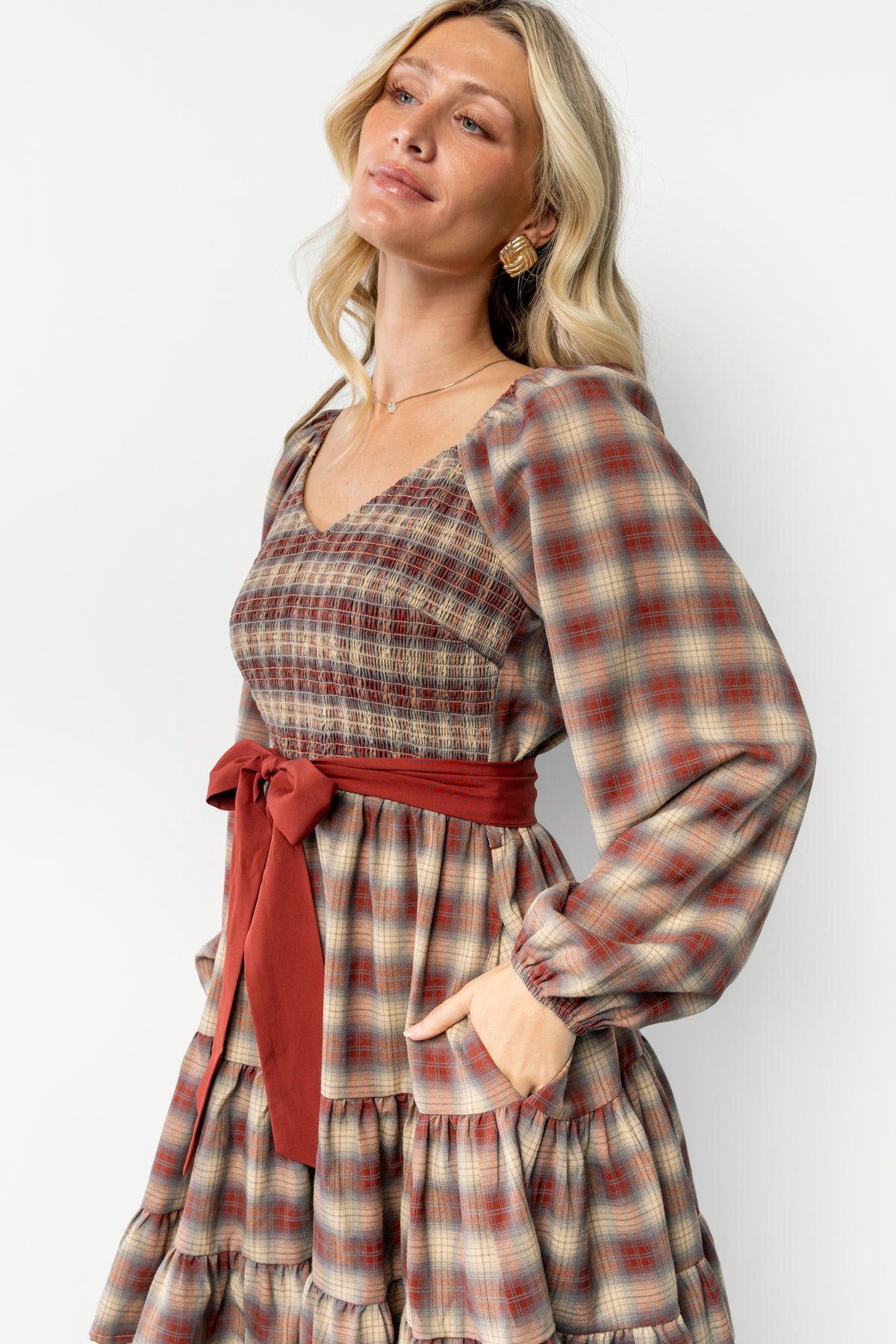 Three-quarter view of Stina Plaid Dress as model turns; highlights hidden side pocket, plaid pattern, and soft cotton-blend fabric drape.