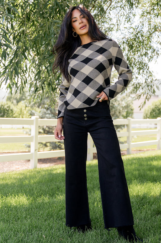 Front view of Linnea argyle sweater in black and natural on model, showing boat neckline, ribbed cuffs, and straight hem for everyday wear.