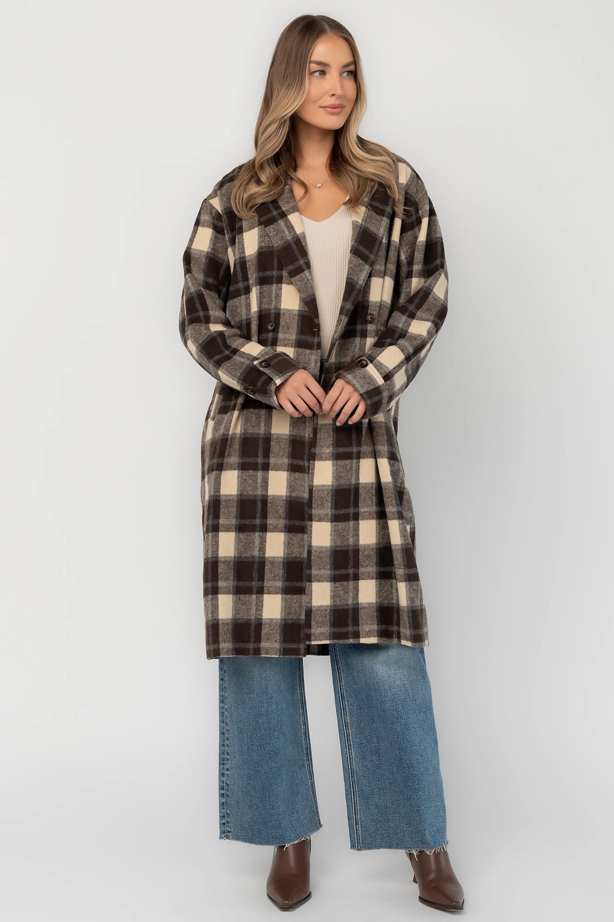Brown plaid double-breasted longline coat with a collared lapel neckline, side pockets, back slit, and relaxed tailored fit.