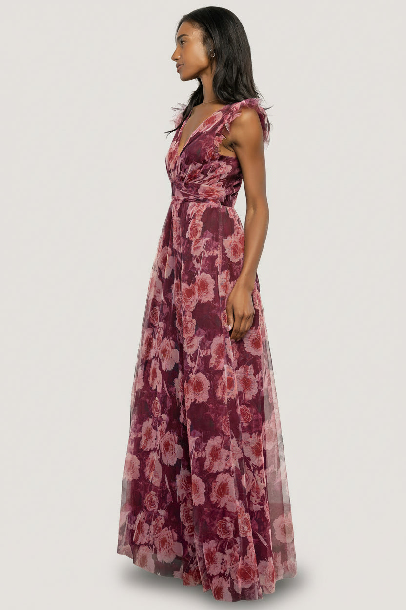 Model walking in Adelyn Maxi Dress Wine Floral, showing movement of the maxi skirt, left leg slit in motion, and soft flutter tank sleeves.