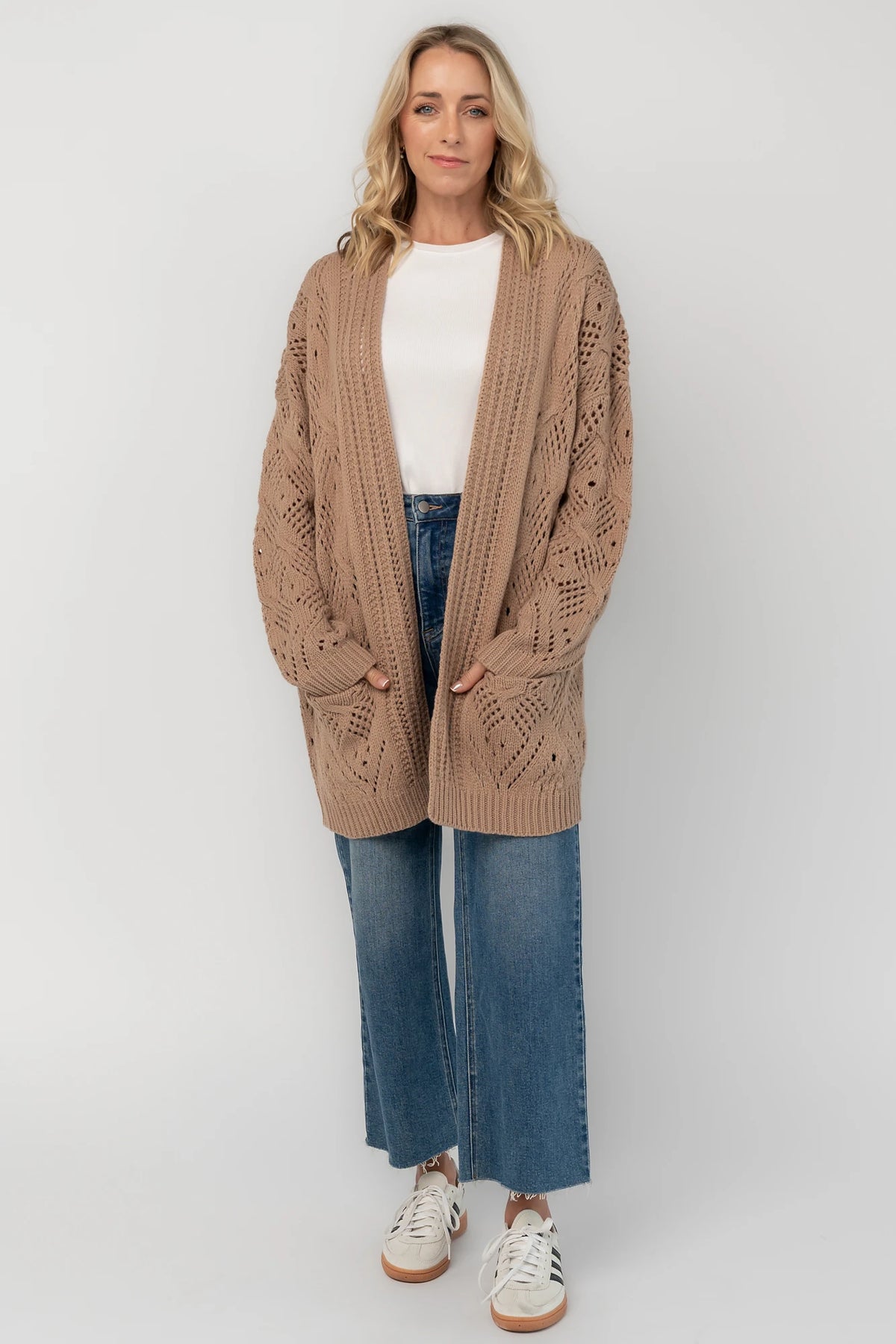 Light mocha open-front pointelle knit cardigan with long balloon sleeves, front patch pockets, ribbed trim, and a relaxed oversized silhouette.