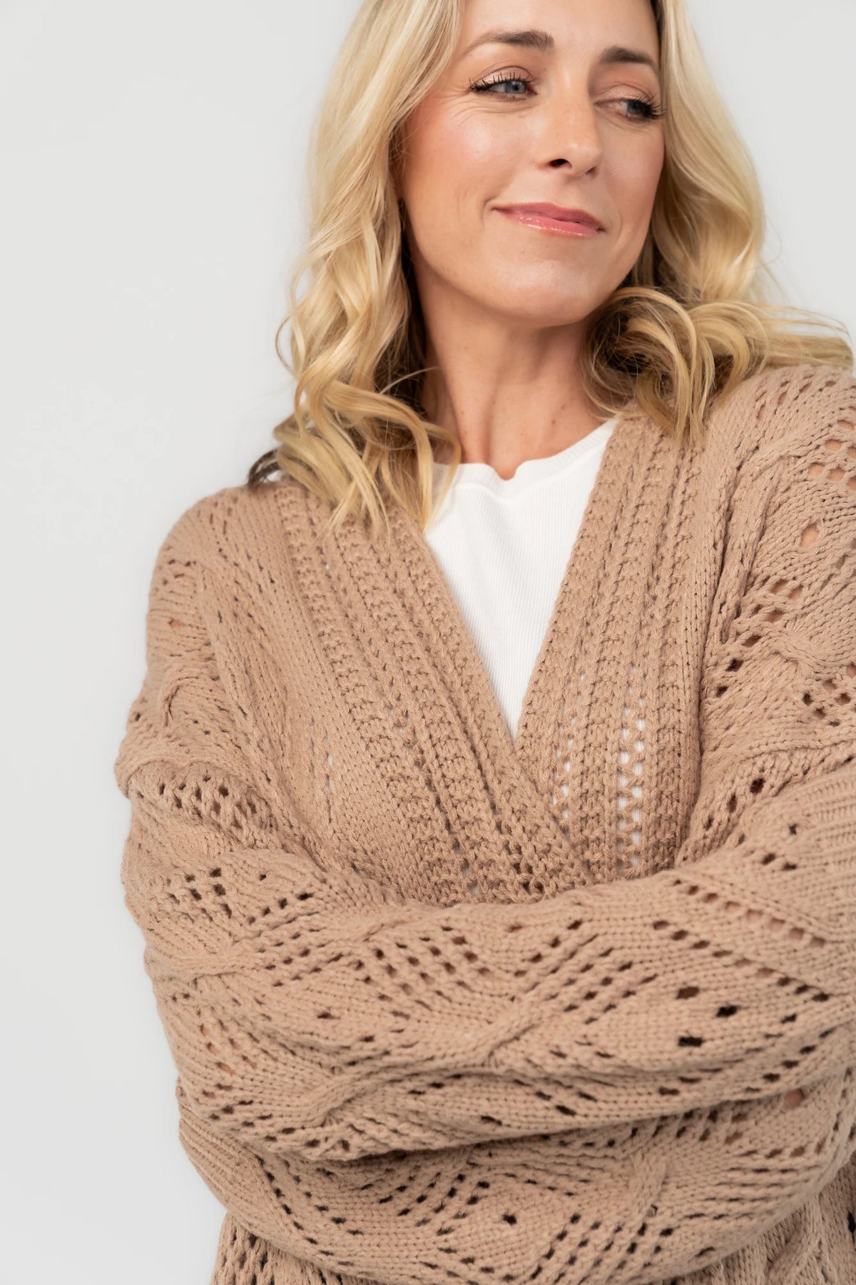 Light mocha open-front pointelle knit cardigan with long balloon sleeves, front patch pockets, ribbed trim, and a relaxed oversized silhouette.
