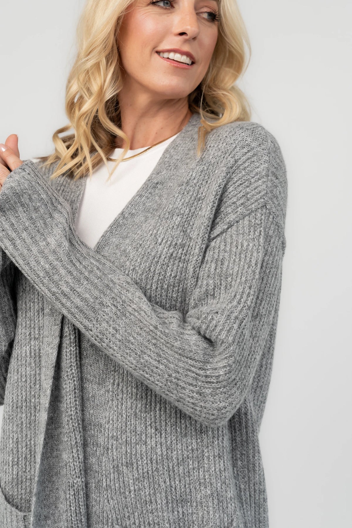 Heather gray ribbed long cardigan with an open front, long sleeves, front patch pockets, and a relaxed full-length silhouette.