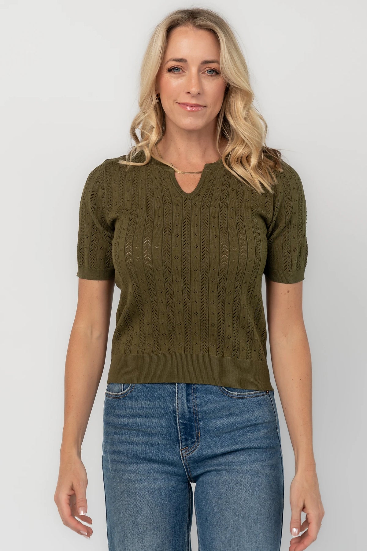 Pointelle knit top with a crew neckline, notch detail, short sleeves, and ribbed cuffs and hem.