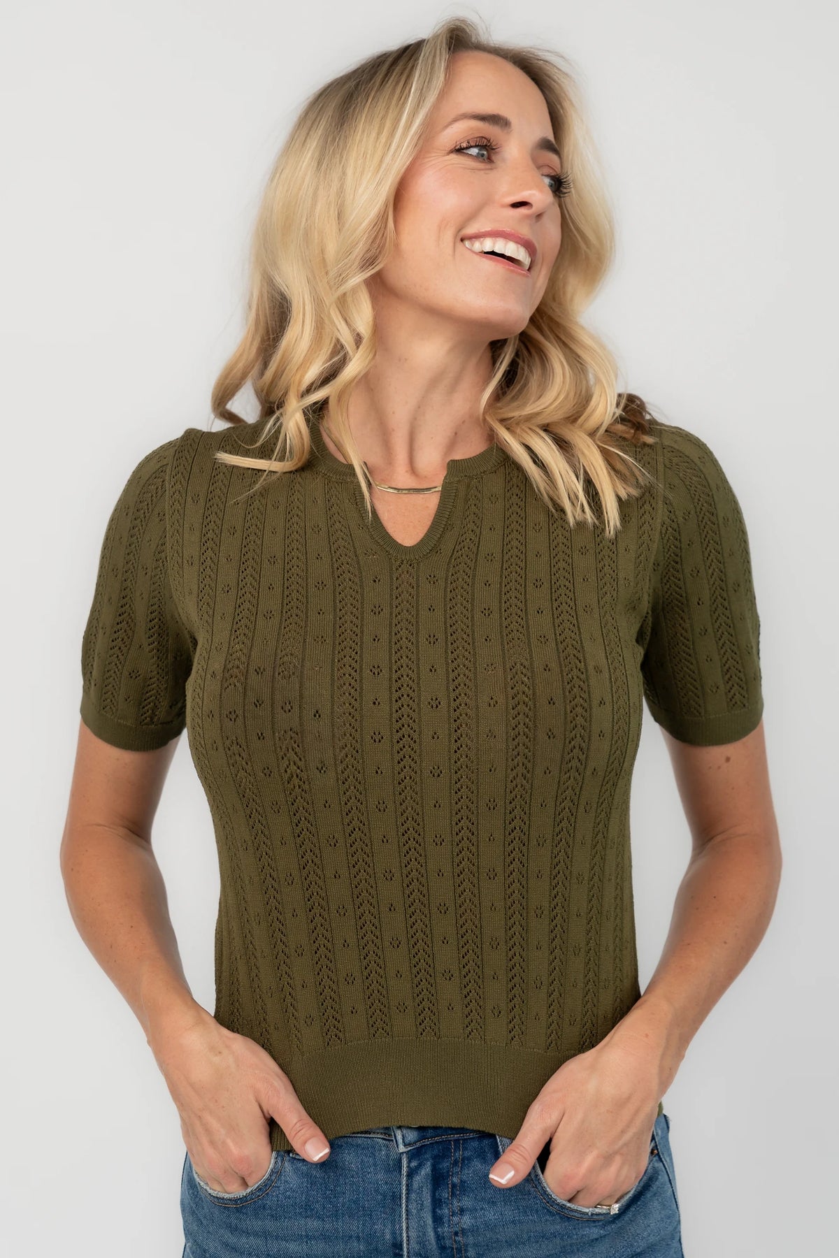 Pointelle knit top with a crew neckline, notch detail, short sleeves, and ribbed cuffs and hem.