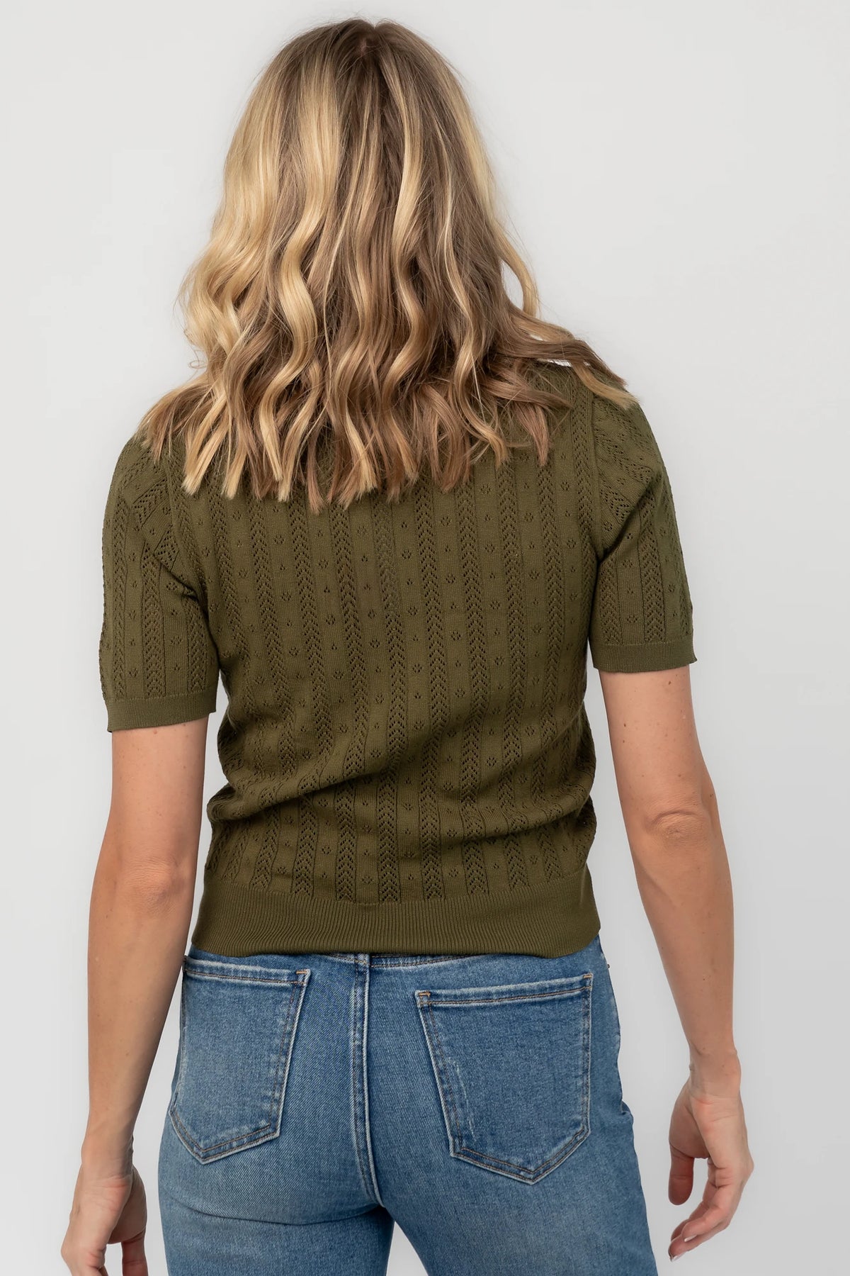 Pointelle knit top with a crew neckline, notch detail, short sleeves, and ribbed cuffs and hem.