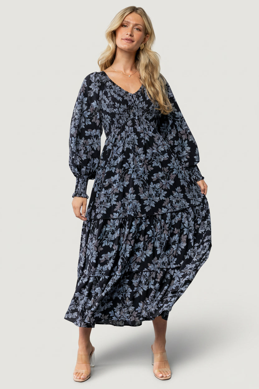 Three-quarter angle of Rayna Smocked Dress showing smocked bodice, long sleeves with smocked cuffs, and soft fabric drape.