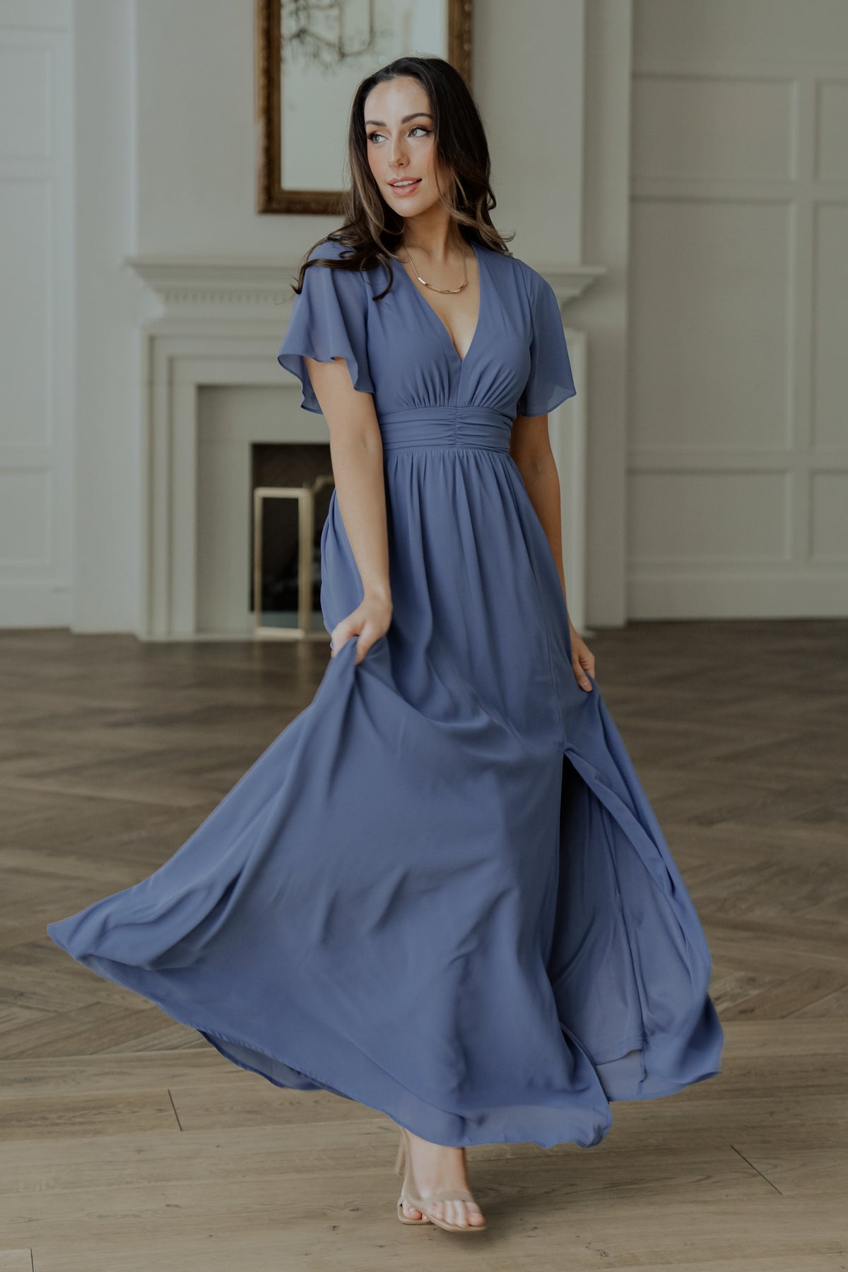 Model walking to show skirt movement and left leg slit, showcasing chiffon drape and the dress’s flowing maxi length.