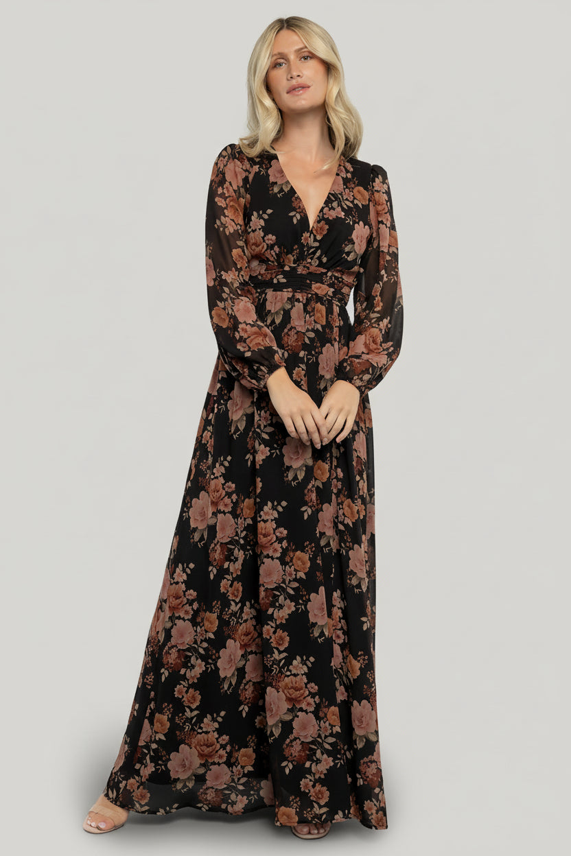 Front view of model wearing Adira Maxi Dress in black with mauve floral print; V-neck, smocked back waist, and flowing chiffon drape.