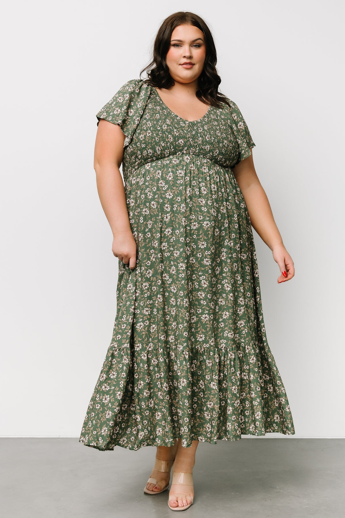 Close-up of the smocked bust and center seam detail, showing stretch, texture, and delicate cream floral motifs on rayon fabric.