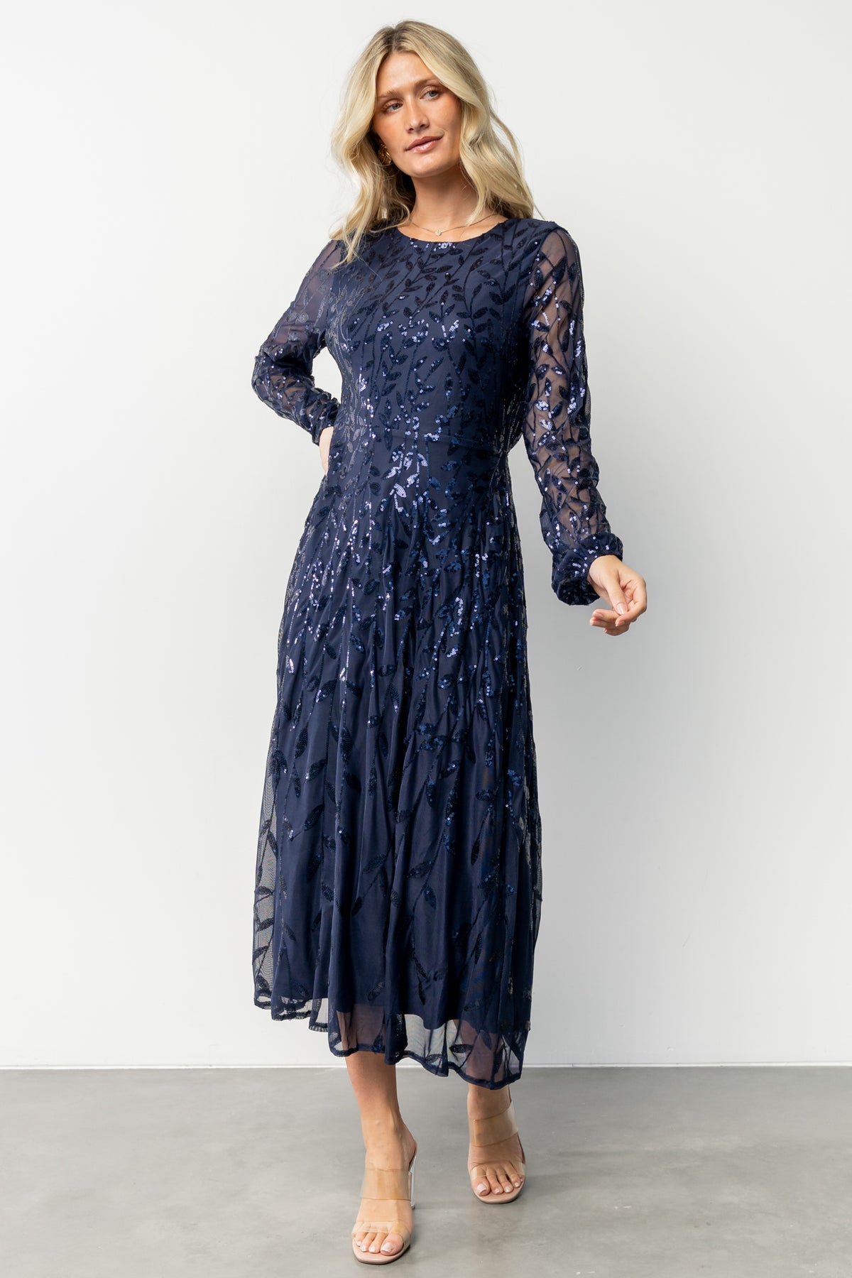 Angled full-length view of navy sequin midi dress, showing A-line drape, knee-to-mid-calf length, and overall silhouette.