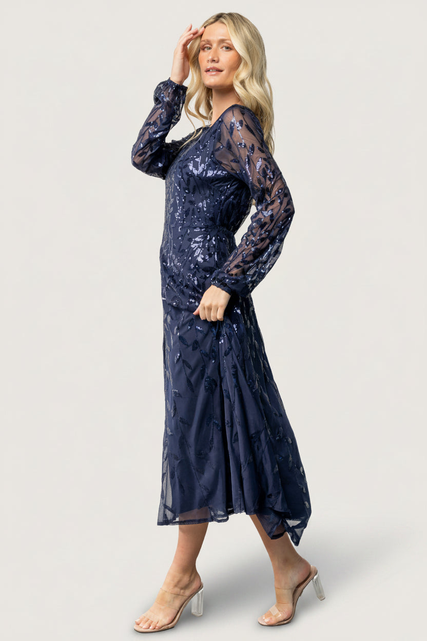 Close-up of navy mesh fabric with dense sequin embellishments, showing texture, sparkle, and stretch in the material.