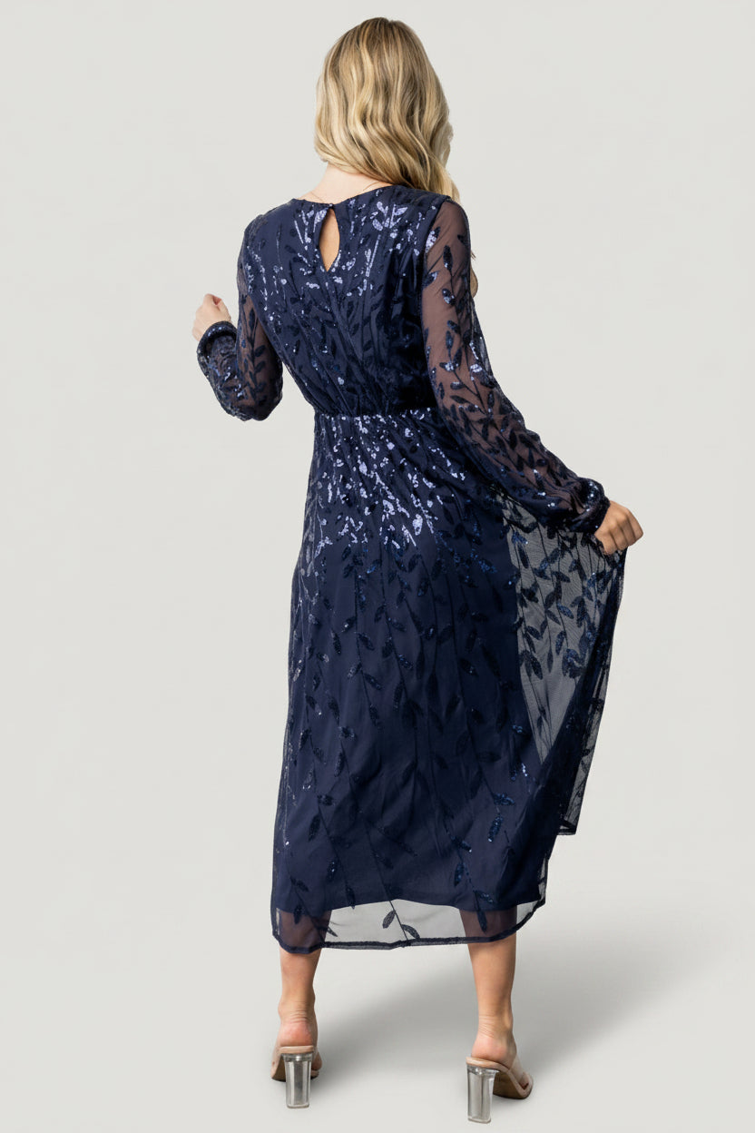 Detail shot of long sheer sleeve with elastic cuff and scattered sequins, highlighting delicate mesh and finished hem.