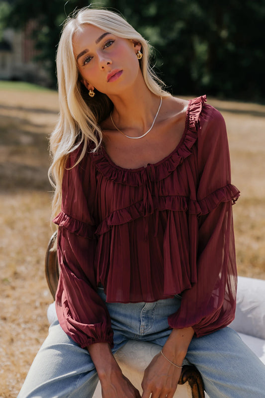 Bellerose Ruffle Top in Burgundy with pleated chiffon, ruffle-trimmed neckline, front tie, and billowy long sleeves.