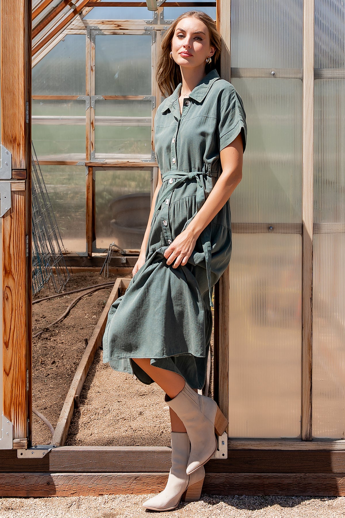 Front view of Logan Button Up Dress in washed green showing collared bodice, functional buttons, cuffed short sleeves, and removable self-tie sash.