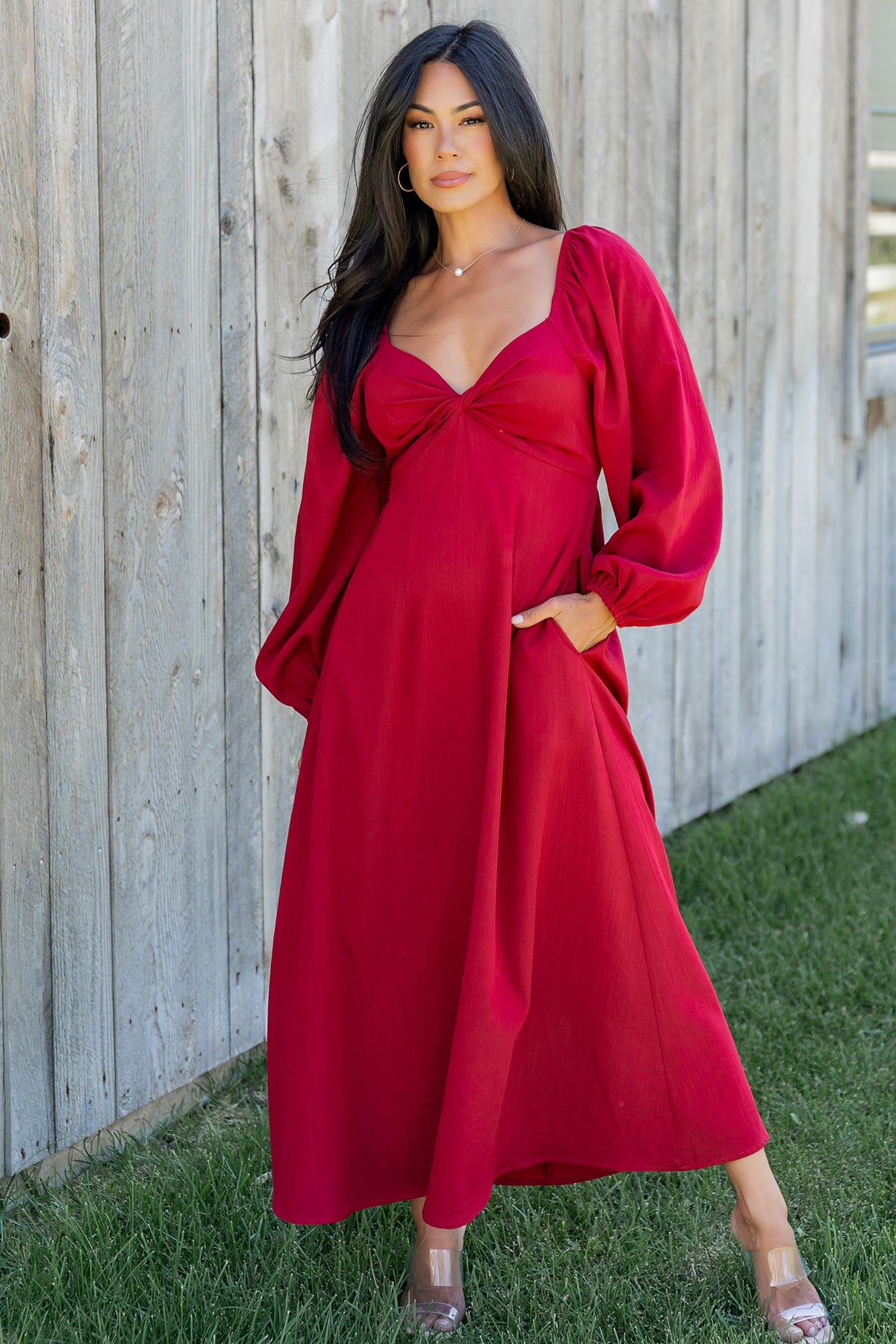 Front view of model wearing scarlet Rosalie Back Tie Dress showing midi length, pleated bodice, and flowy long sleeves.