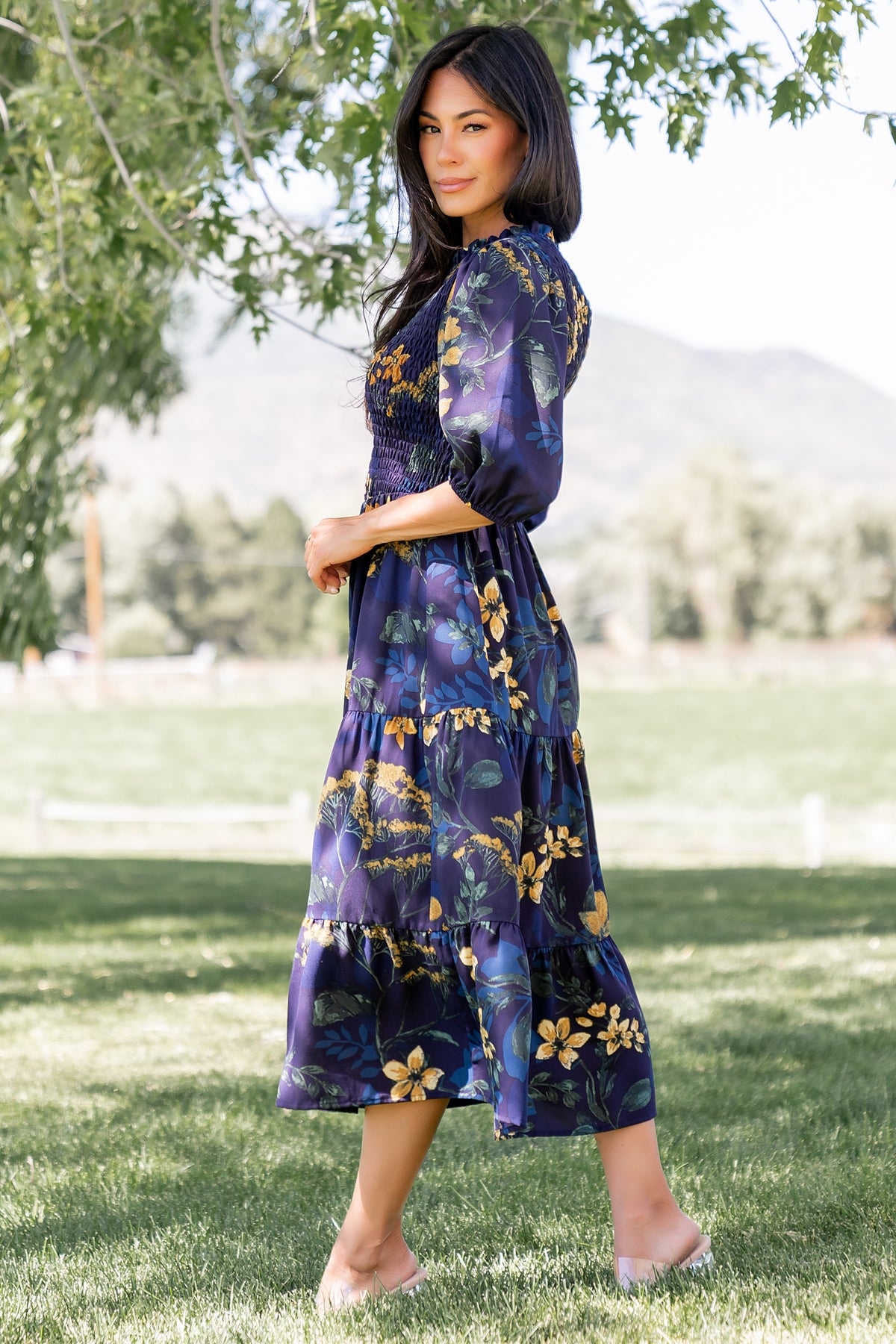 Detail view of the mid-length sleeve with elastic cuff and ruffle neckline on the navy Lena Tiered Midi Dress, emphasizing construction.