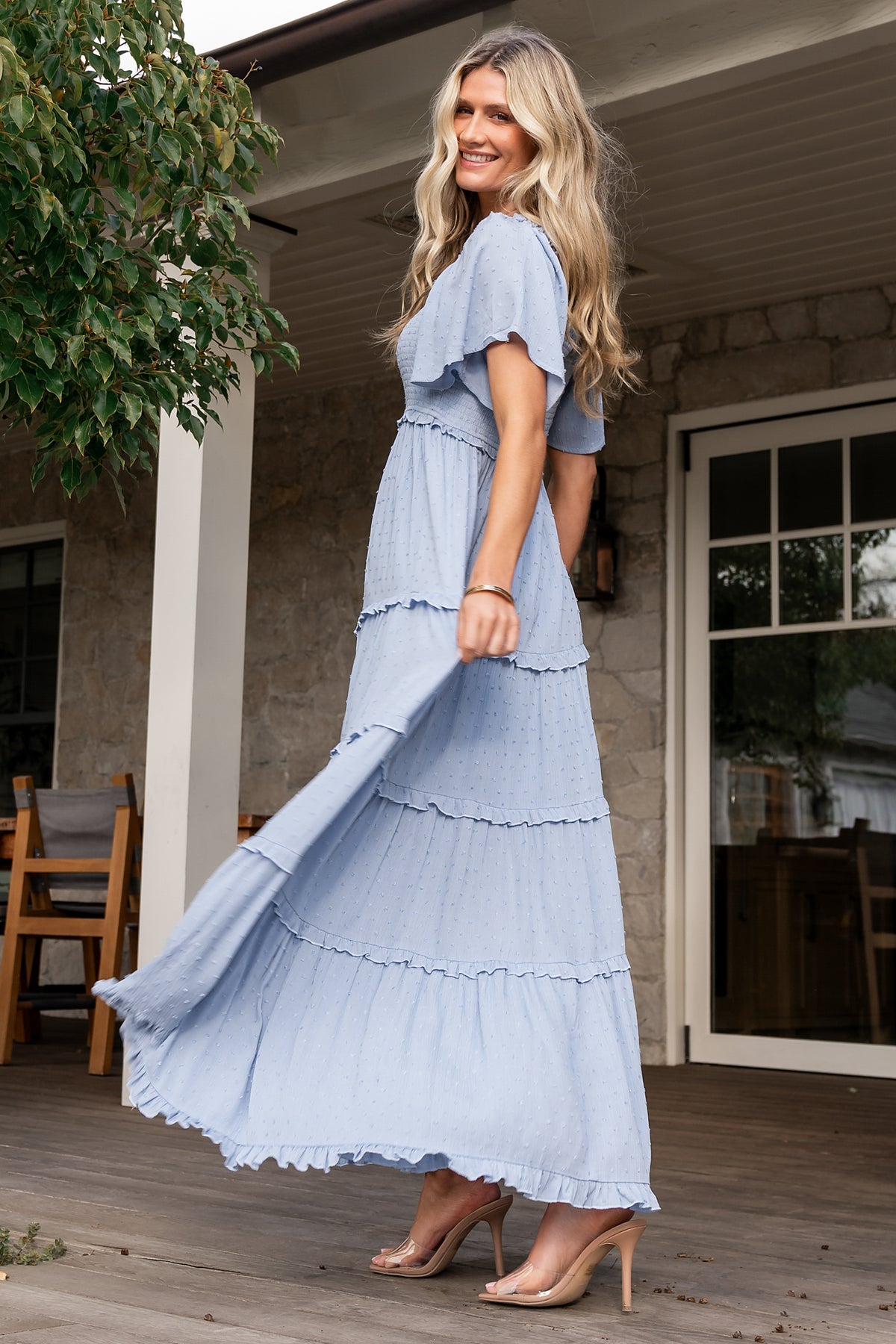 Side and movement shot of dusty blue Lenora dotted maxi dress highlighting tiered ruffle skirt, soft drape of rayon fabric, and mid-thigh lining.