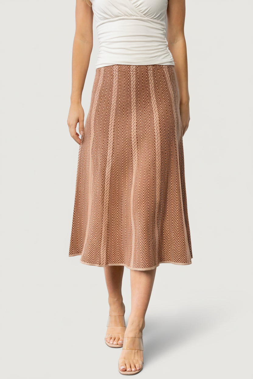 Front view of Astrid Midi Skirt in rust and taupe petite chevron knit on model, high-rise A-line silhouette, midi length, elastic waistband.