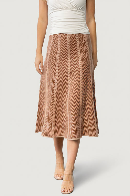 Front view of Astrid Midi Skirt in rust and taupe petite chevron knit on model, high-rise A-line silhouette, midi length, elastic waistband.