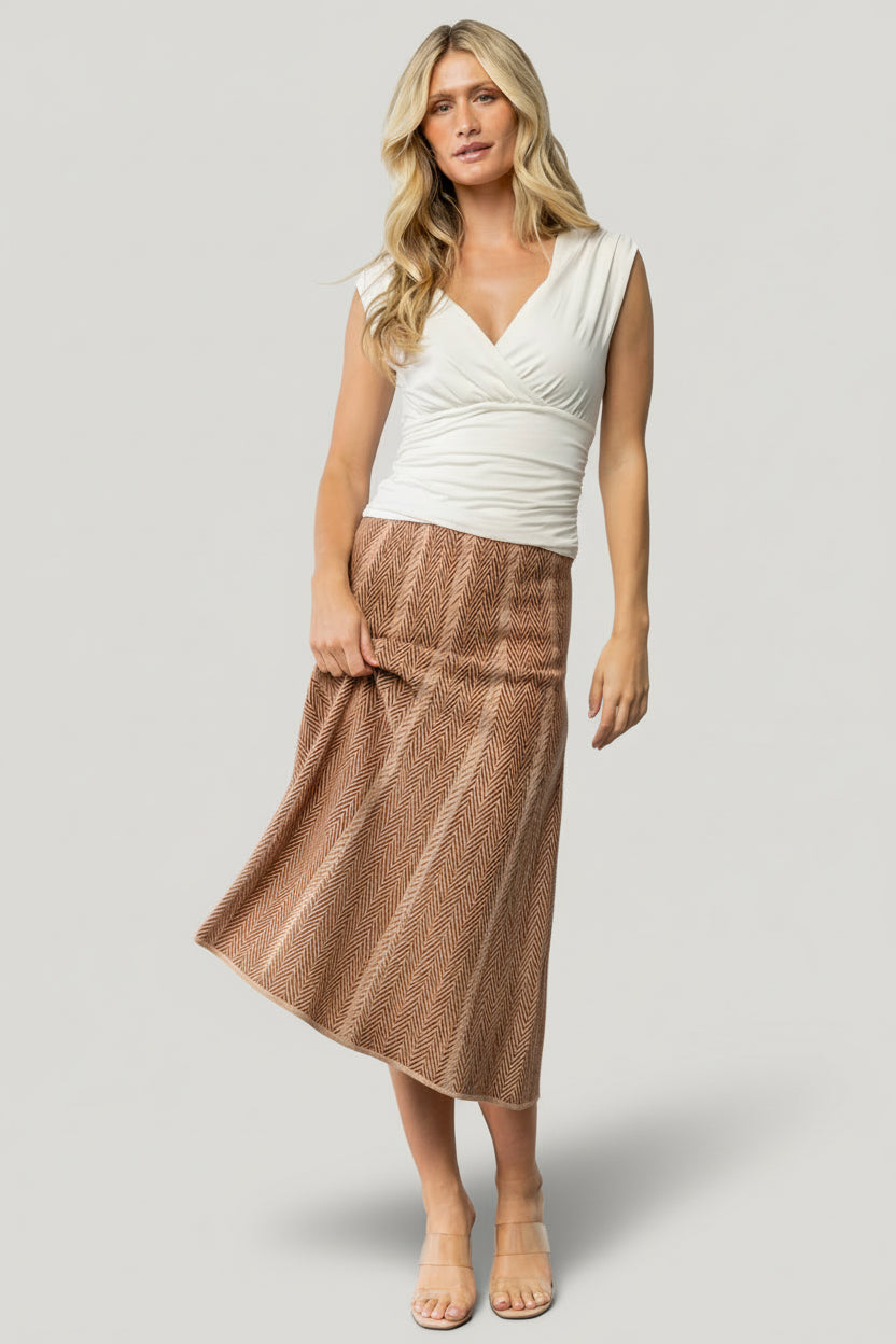 Styled outfit image of Astrid Midi Skirt in rust print paired with knitwear and accessories to illustrate seasonal versatility.