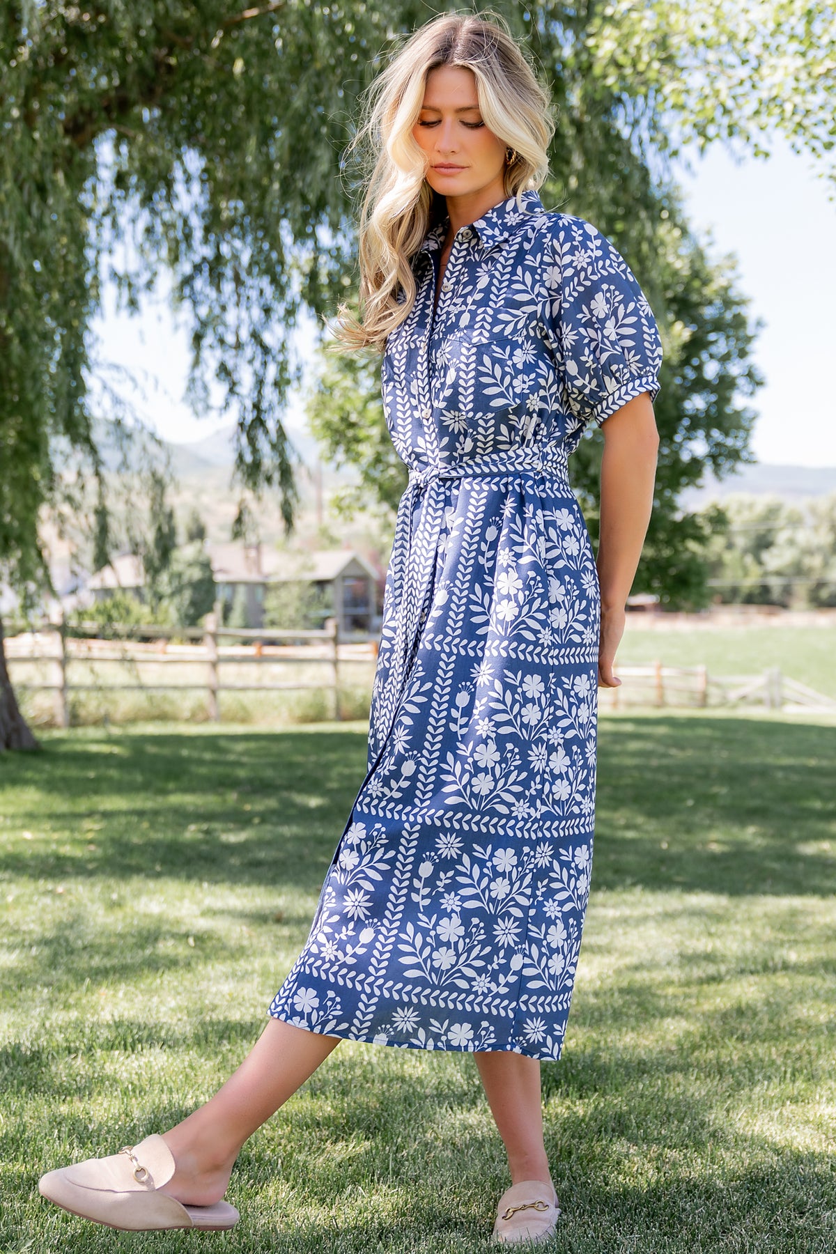 Three-quarter view showing short puff sleeve and collared neckline on Karla midi dress with delicate off-white floral pattern on deep slate.
