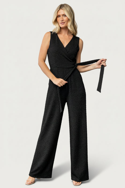 Full-length front view of Natasha Jumpsuit in true black on model, showing surplice neckline, tank sleeves and wide-leg silhouette.
