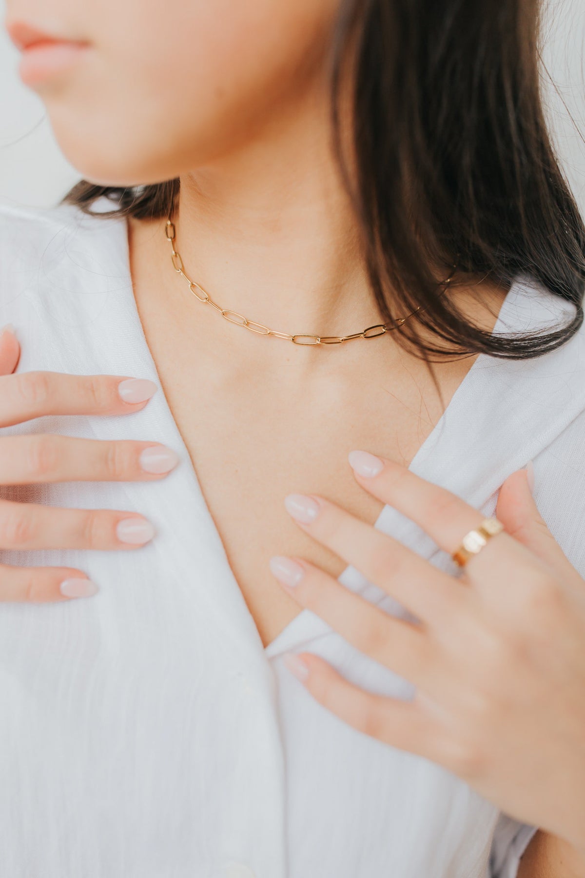 Artful close-up of The Eloise Necklace catching light across the elongated gold links to demonstrate finish and subtle shine in wear.