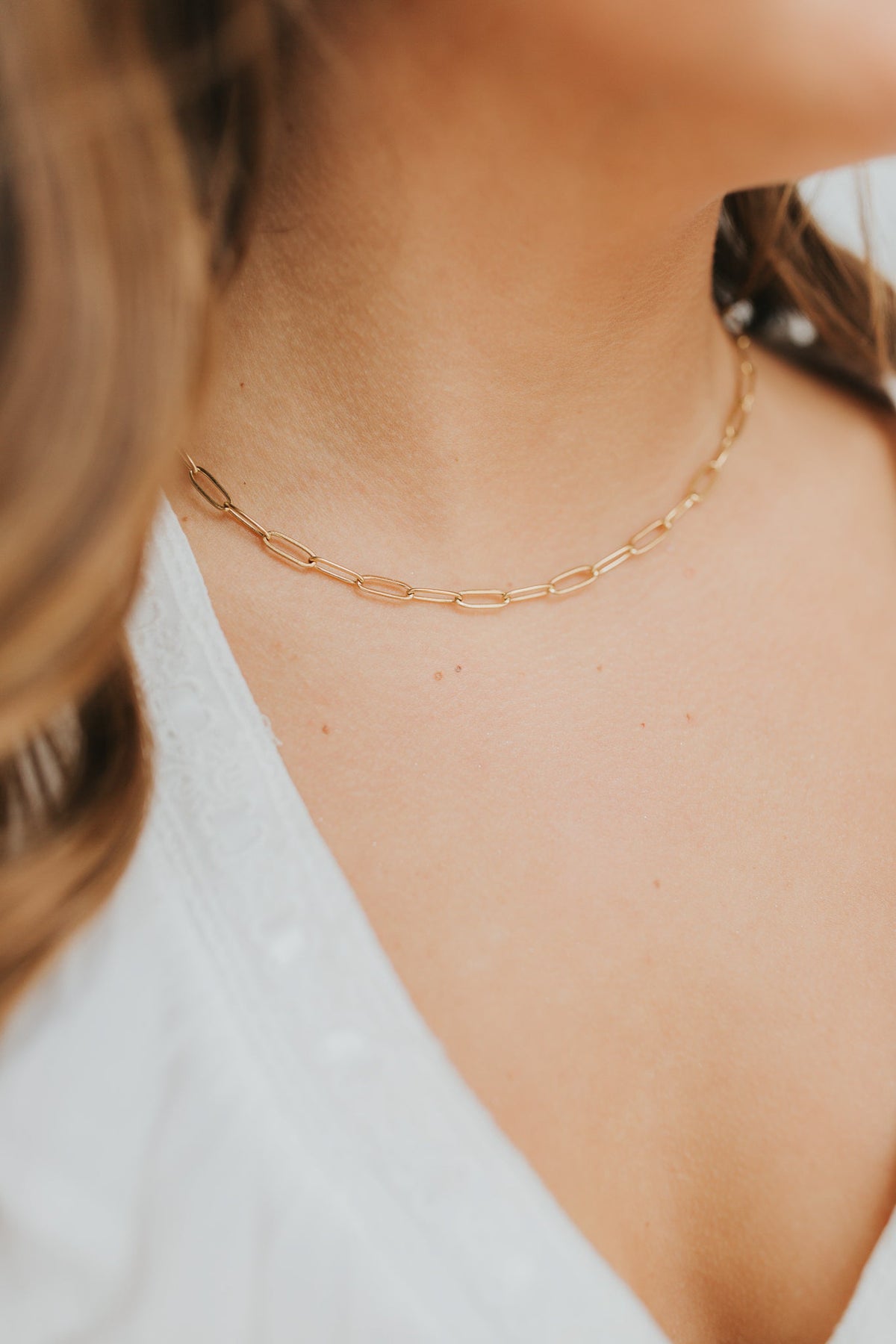 Close-up of The Eloise Necklace showing elongated 18K gold-plated links and a polished lobster clasp on a clean white background, highlighting link detail.
