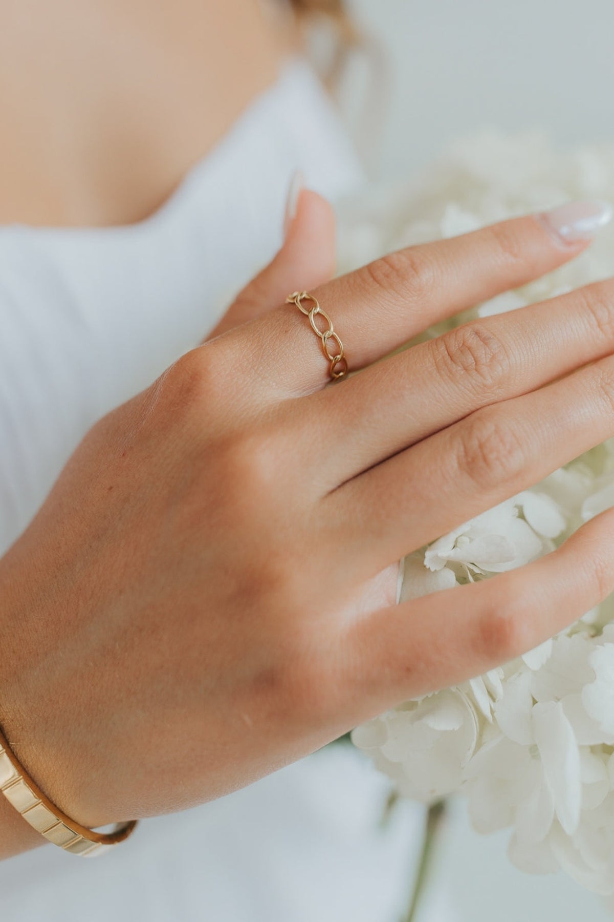 Close-up of The Emma Ring showing polished 18K gold-plated chain-link band on a neutral background, highlighting link detail and finish.