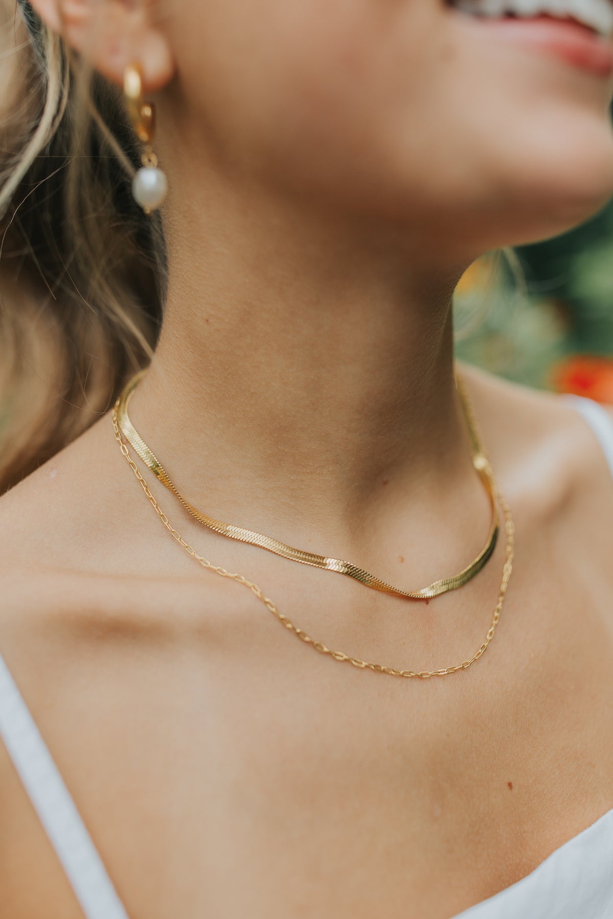 Close-up of the Christina layered double-chain necklace in warm gold, showing both fine chains, lobster clasp, and delicate finish on white background.