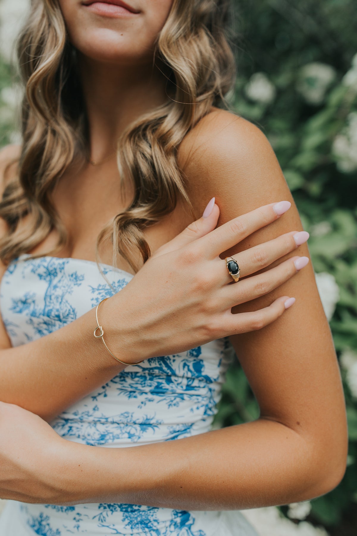 Top-down view of Maddie ring showing oval black onyx face, sculpted wrap band contours, and 18K gold-toned plating details.